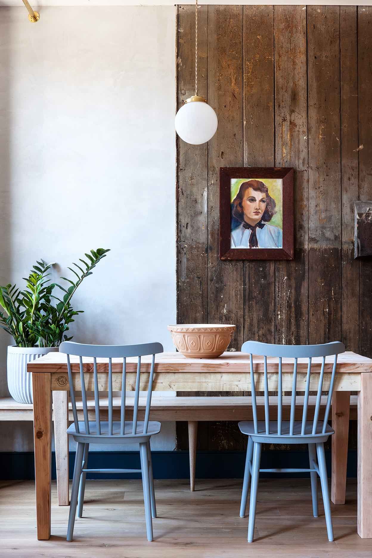 Weathered barn wood meets Scandinavian simplicity in the hotel's intimate dining space, where vintage portraits and modern pendant lighting create unexpected charm.