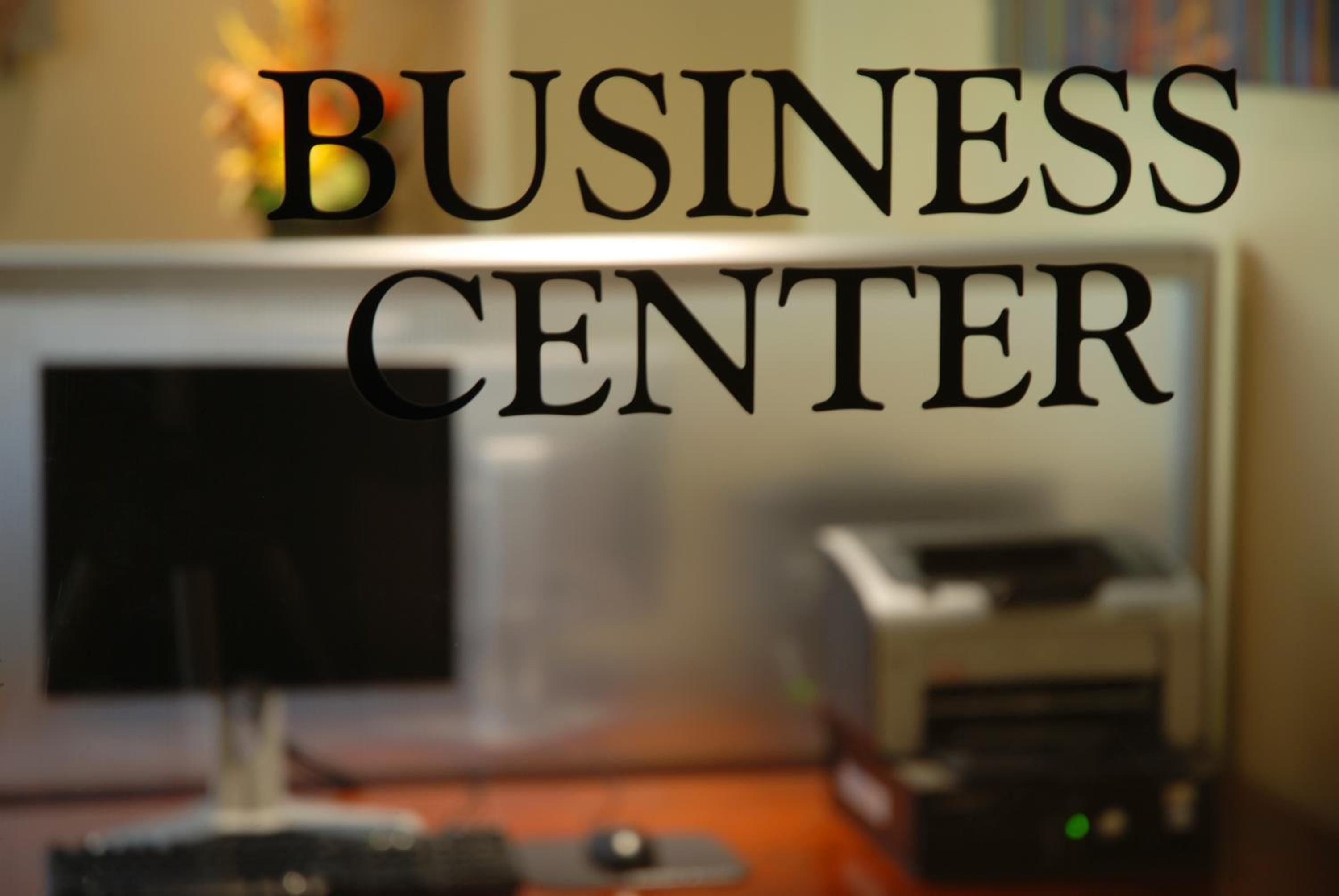 Sleek business center signage overlooks modern workstations where guests can handle professional needs amid the hotel's polished, contemporary atmosphere.