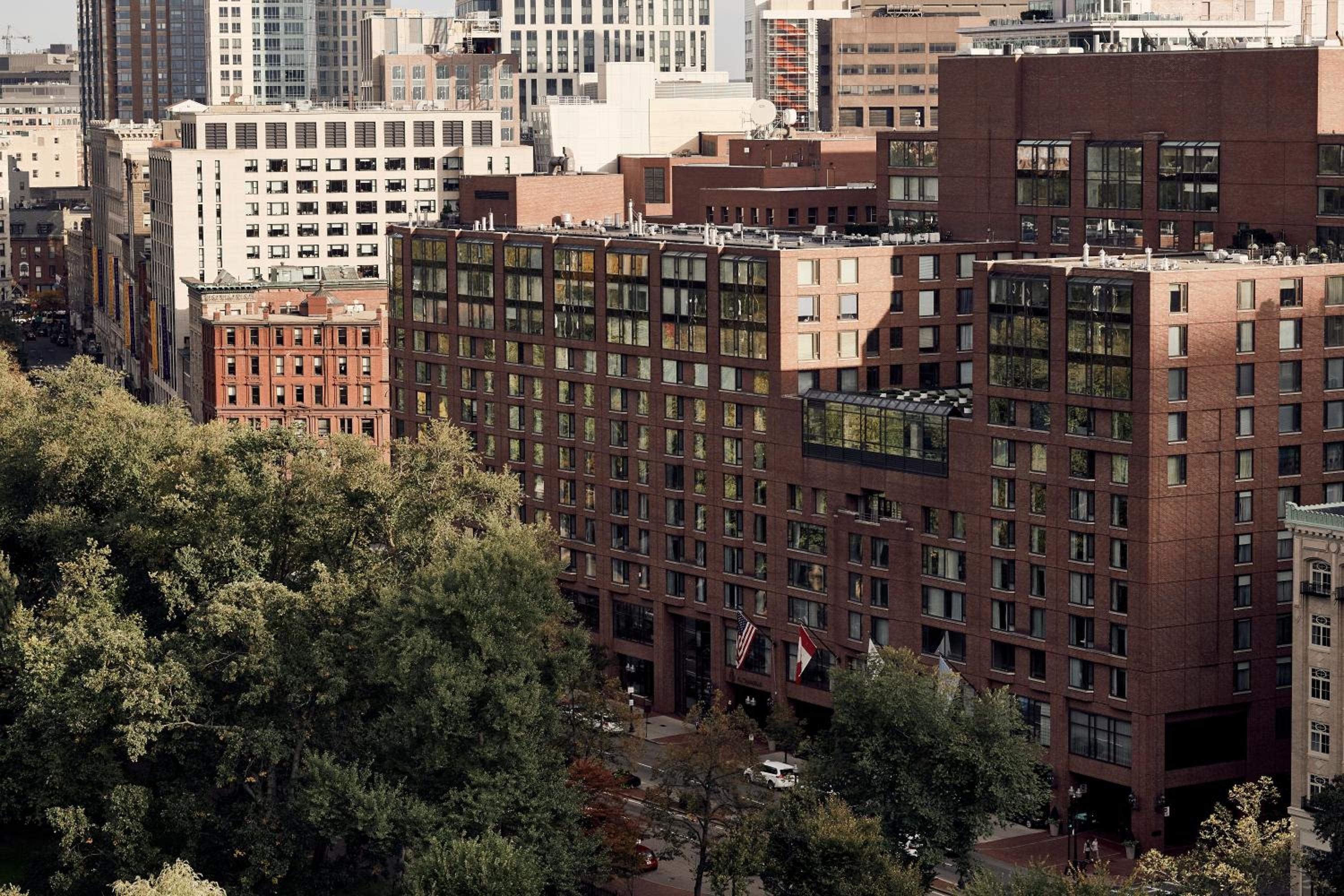 Warm brick facades blend seamlessly into Boston's historic Back Bay neighborhood, where tree-lined streets frame this elegant urban retreat amid the city's architectural tapestry.