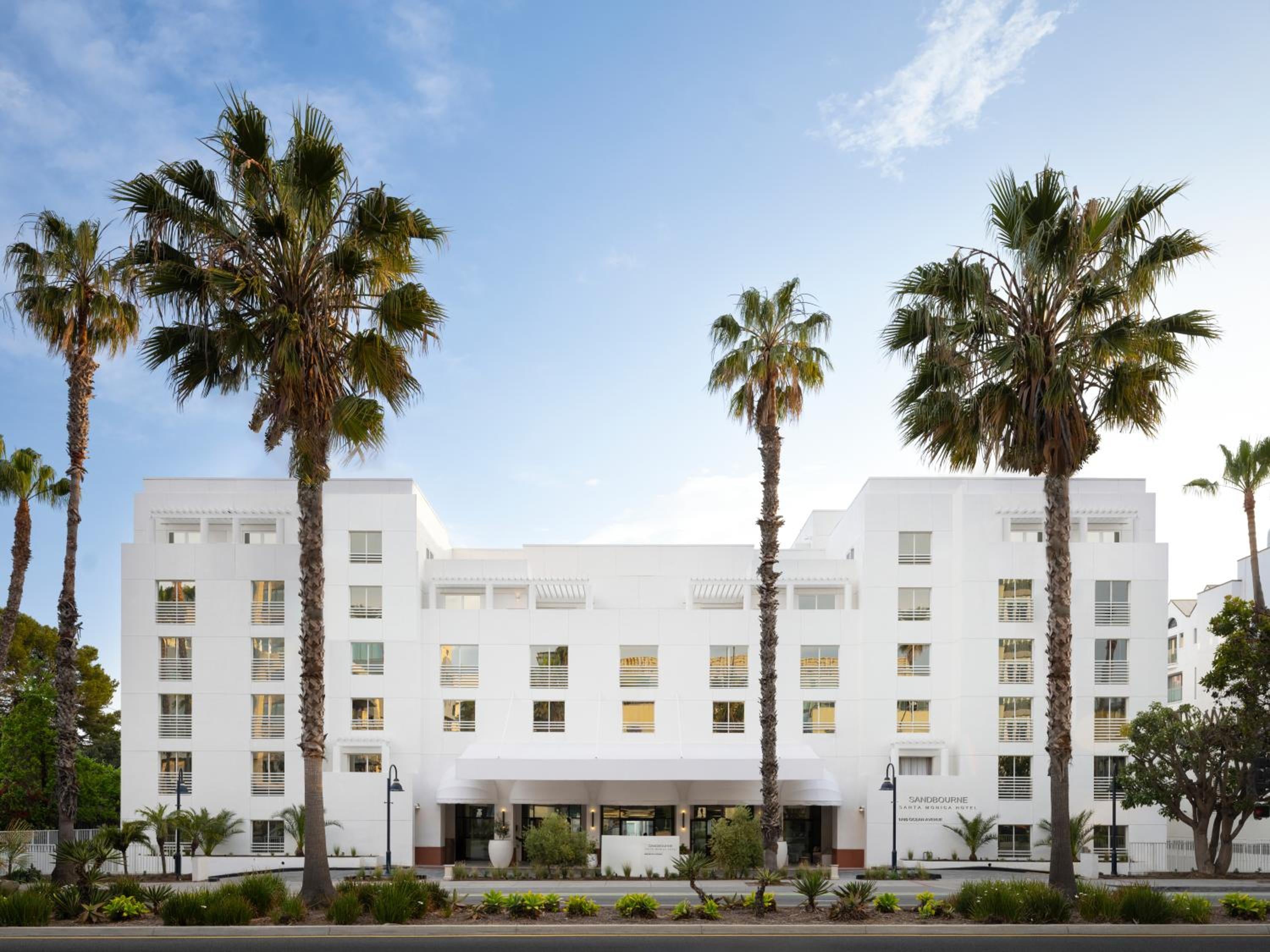 Crisp white facades and towering palms create an instant California mood along this boutique hotel's welcoming streetscape, where modern minimalism meets Santa Monica's laid-back luxury.