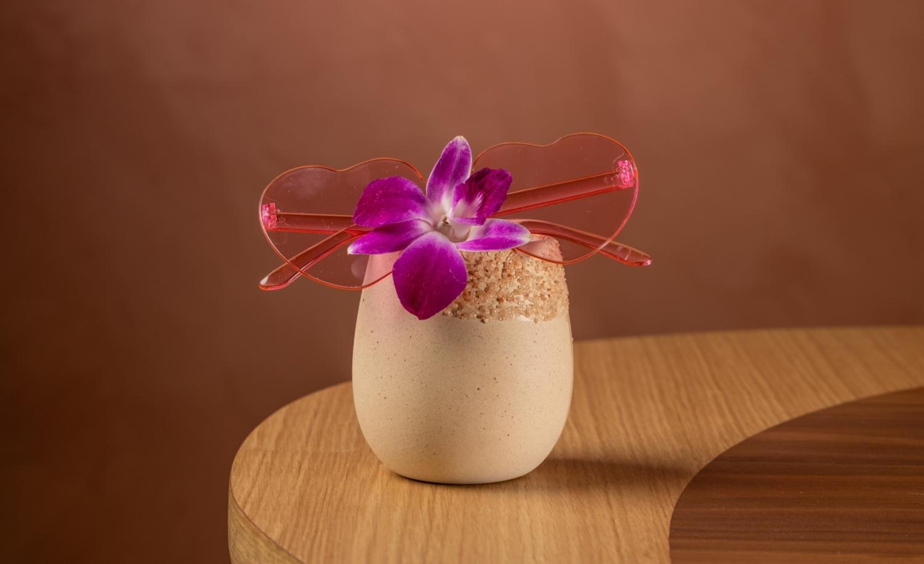 Artful presentation meets culinary craft in this delicate dessert garnished with vibrant orchids, showcasing the hotel's commitment to refined dining experiences that delight all senses.