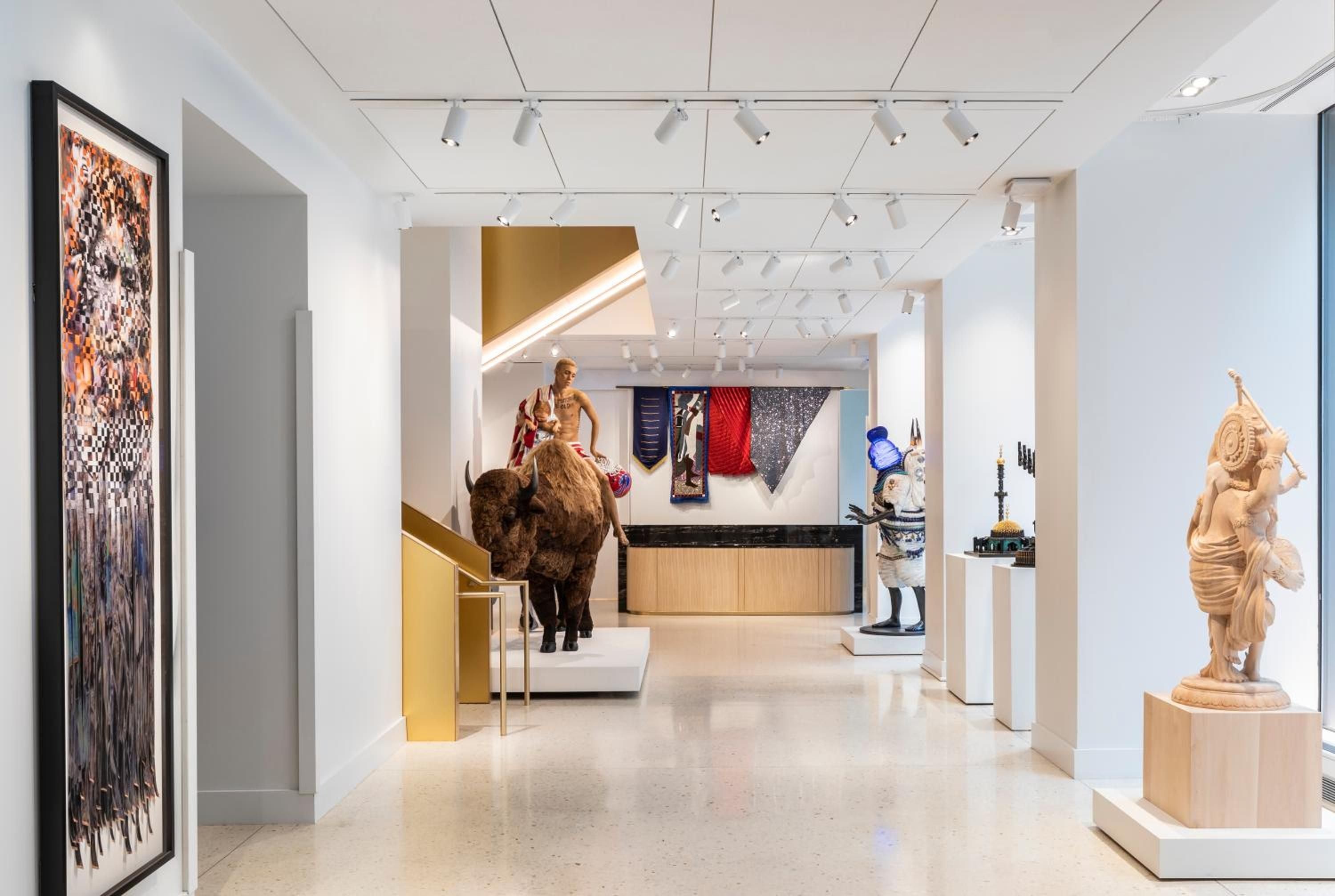 Contemporary sculptures and vibrant textiles transform the sleek gallery spaces, where track lighting illuminates everything from classical statuary to bold modern installations throughout the hotel's museum corridors.