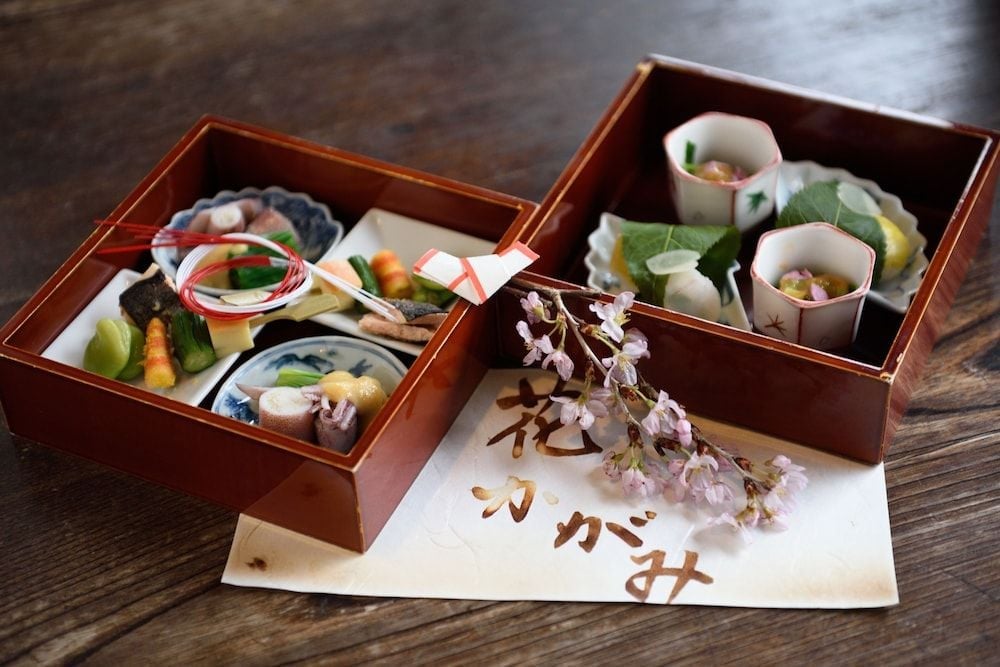 Exquisite kaiseki cuisine arrives in lacquered boxes, each delicate morsel artfully arranged—a celebration of seasonal Japanese flavors and centuries-old culinary traditions.