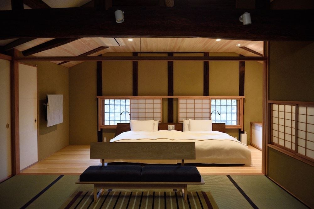 Warm tatami mats and honey-toned wood create an intimate sanctuary where shoji screens filter gentle light across minimalist furnishings in this elevated sleeping alcove.