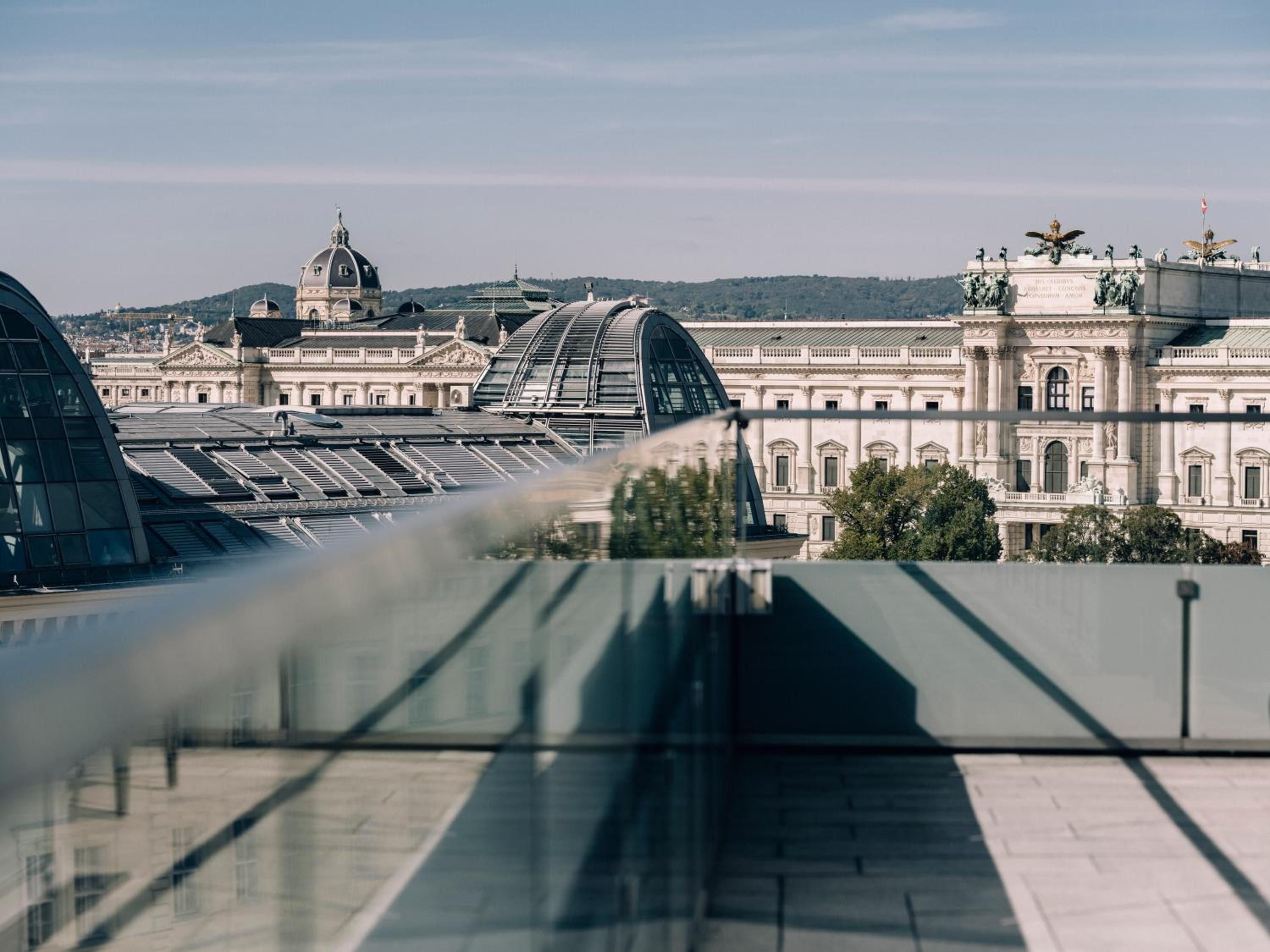 Glass reflections frame Vienna's imperial grandeur from the hotel's elevated vantage point, where baroque palaces and modern domes create a captivating architectural dialogue.