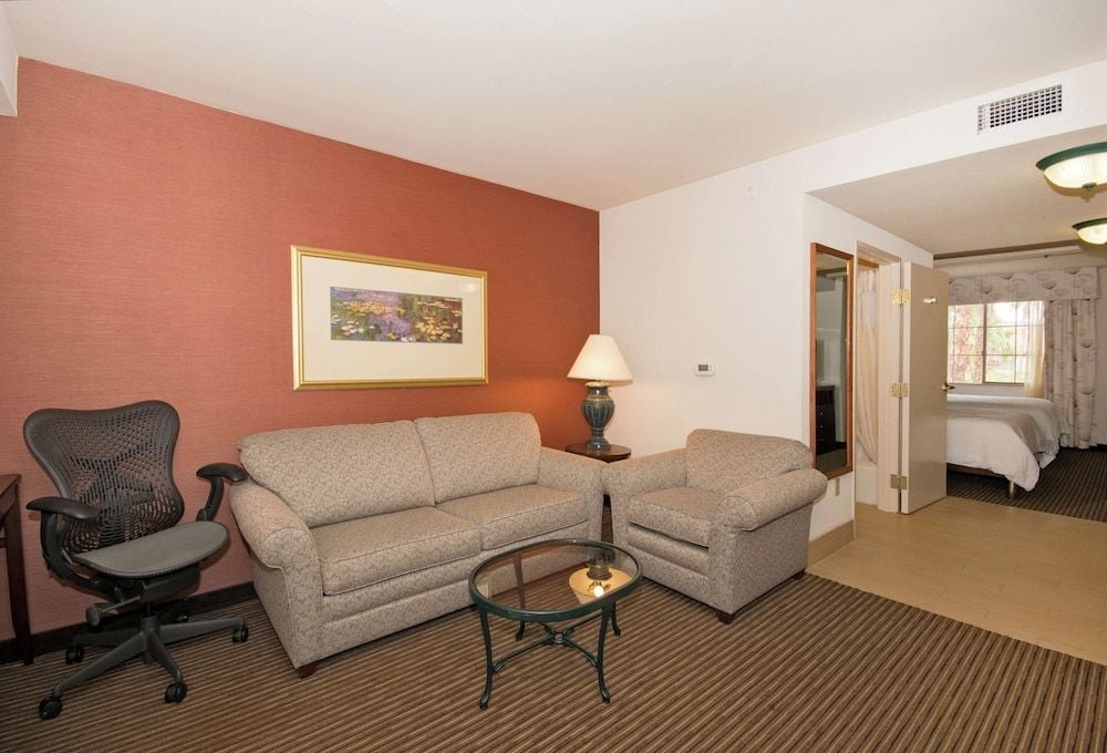 Warm terracotta walls and plush seating create an inviting living space, where modern comfort meets desert-inspired design in this thoughtfully appointed suite.