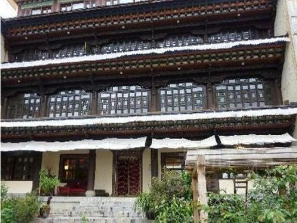 Intricate wooden balconies cascade down this traditional Bhutanese architecture, where hand-carved details and latticed windows create mesmerizing geometric patterns against weathered timber.