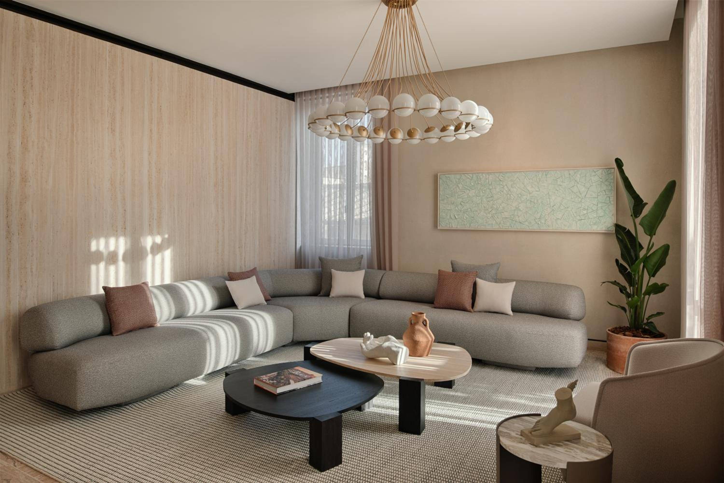 Sunlight streams through sheer curtains onto the modular sofa's sage cushions, where terracotta accents and a sculptural chandelier create intimate warmth in this thoughtfully curated living space.