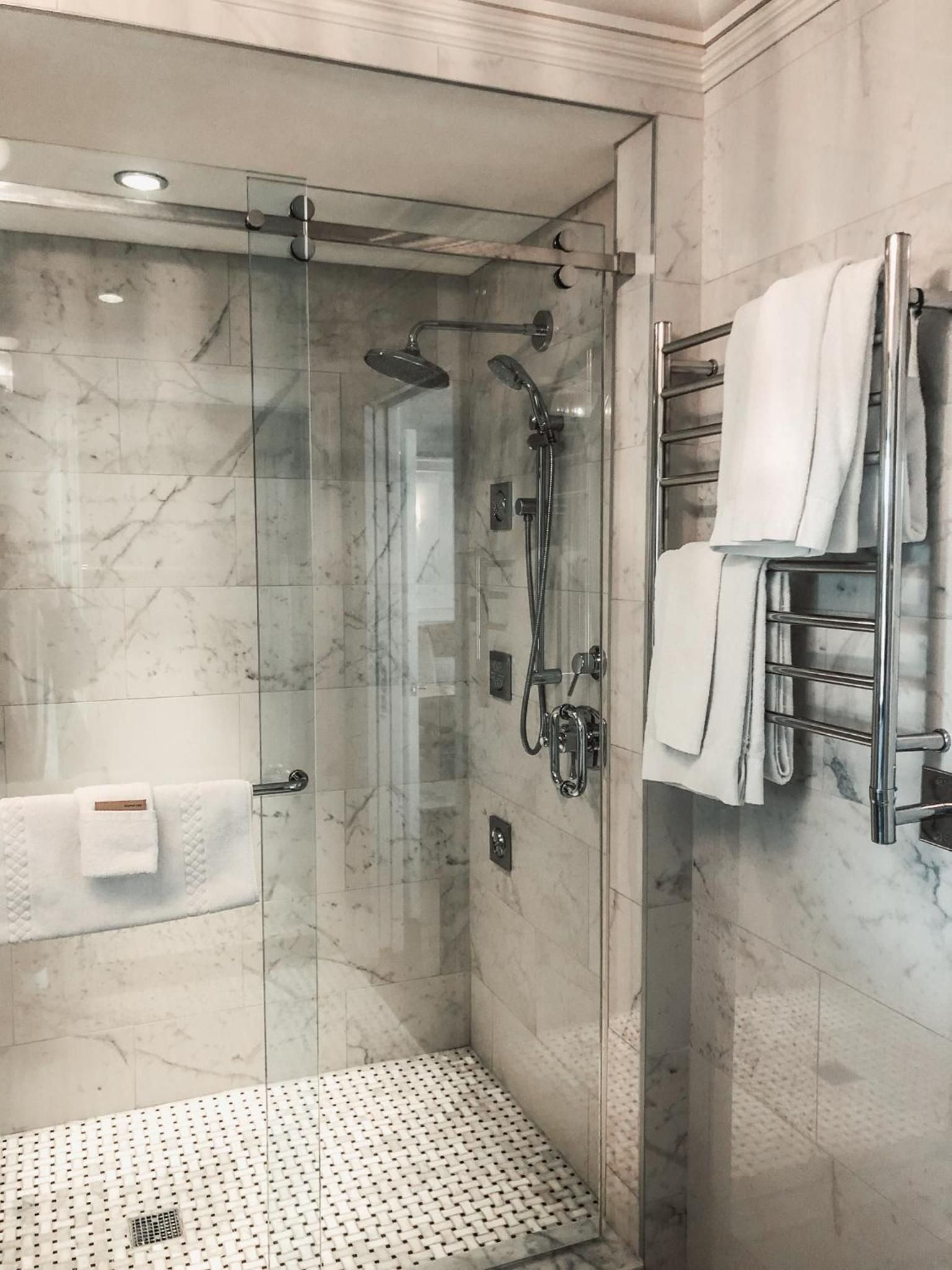 Carrara marble surrounds create a spa-like sanctuary, where rainfall showers and heated towel rails transform daily rituals into moments of pure indulgence.