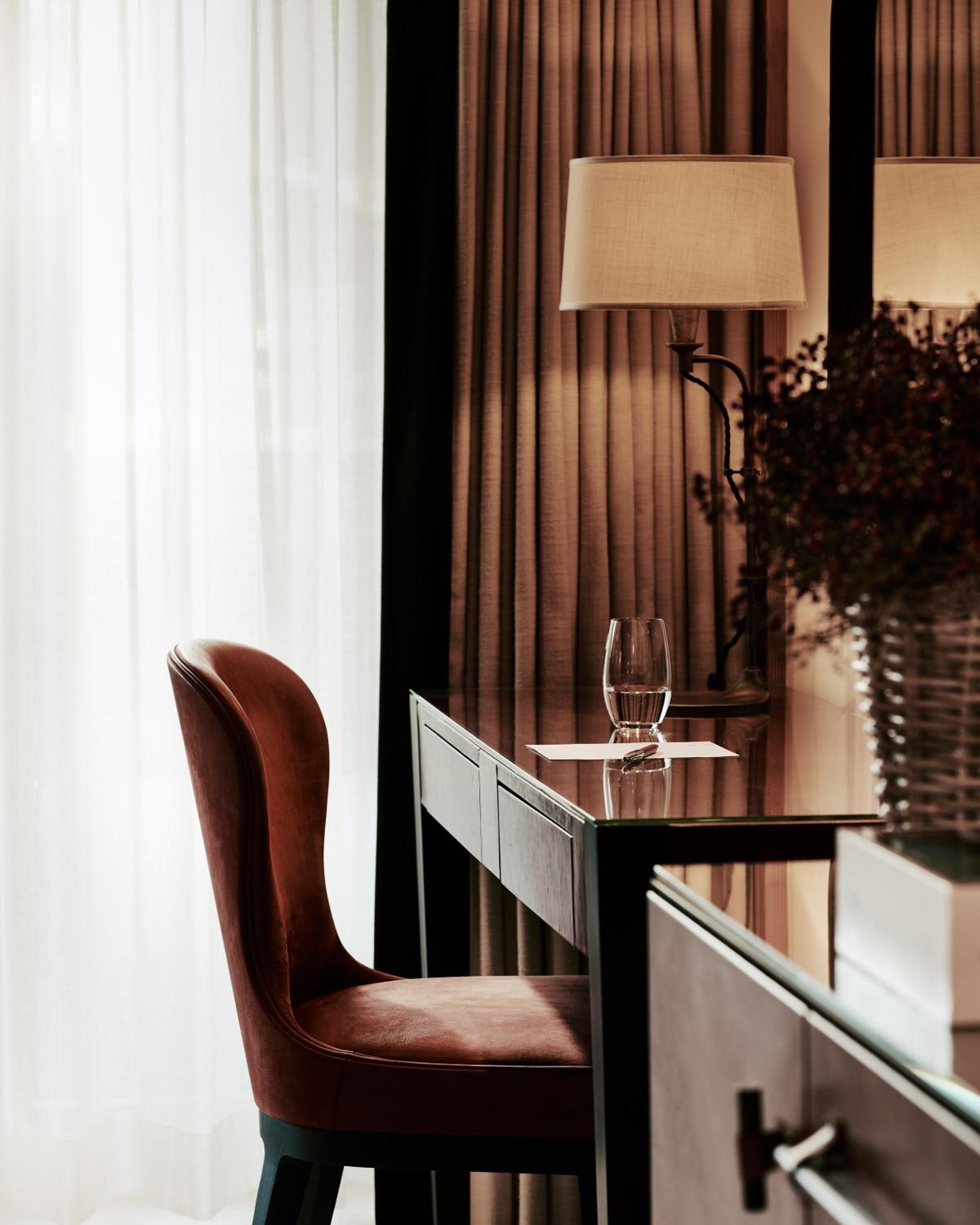 Cognac leather and warm wood create an intimate writing nook where golden hour light filters through silk curtains, perfect for evening correspondence with a glass of wine.