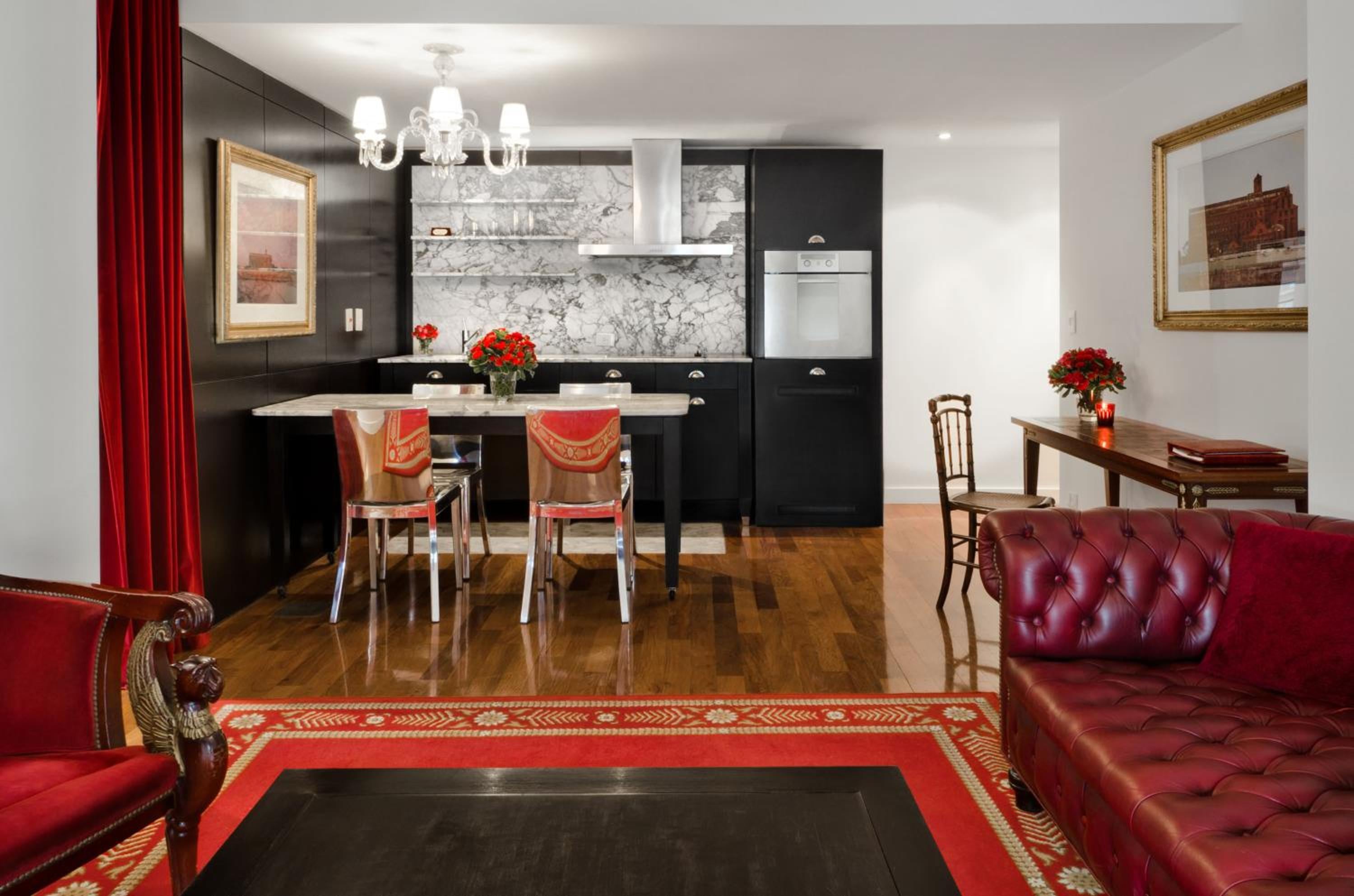 Rich burgundy leather and gleaming hardwood floors create an elegant living space where marble kitchen details meet classic Argentine sophistication in this thoughtfully appointed suite.