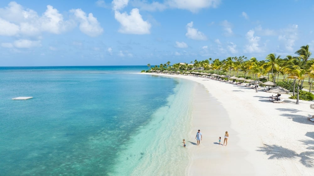 Pristine white sand meets impossibly turquoise waters at this private Antiguan hideaway, where swaying coconut palms frame an endless crescent of Caribbean perfection.