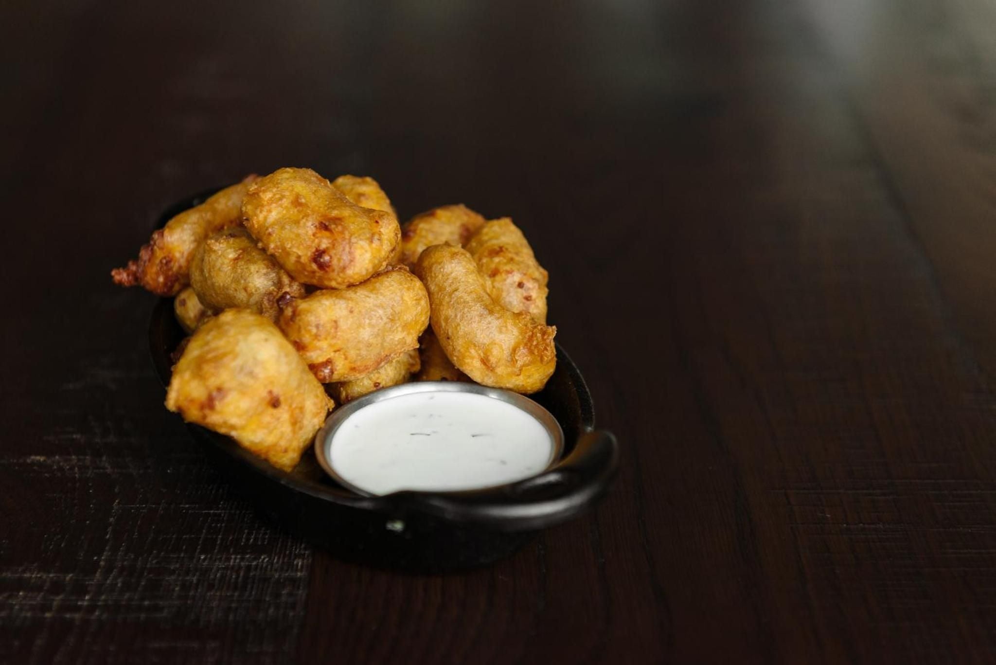 Golden-battered cheese curds arrive piping hot with cool ranch dipping sauce, showcasing the hotel's commitment to elevated Wisconsin comfort food classics.