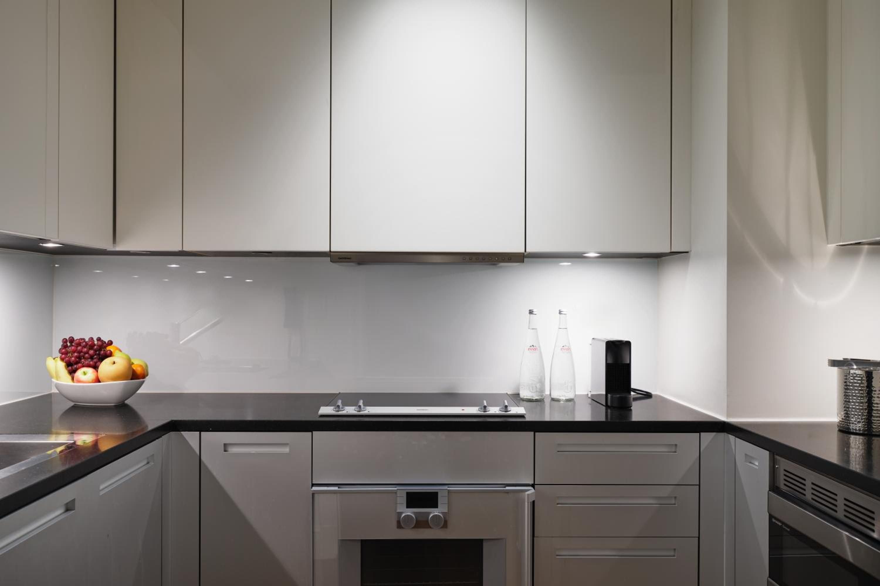 Sleek gray cabinetry and black granite countertops create a sophisticated culinary workspace, where morning coffee feels like a ritual in this polished kitchen sanctuary.