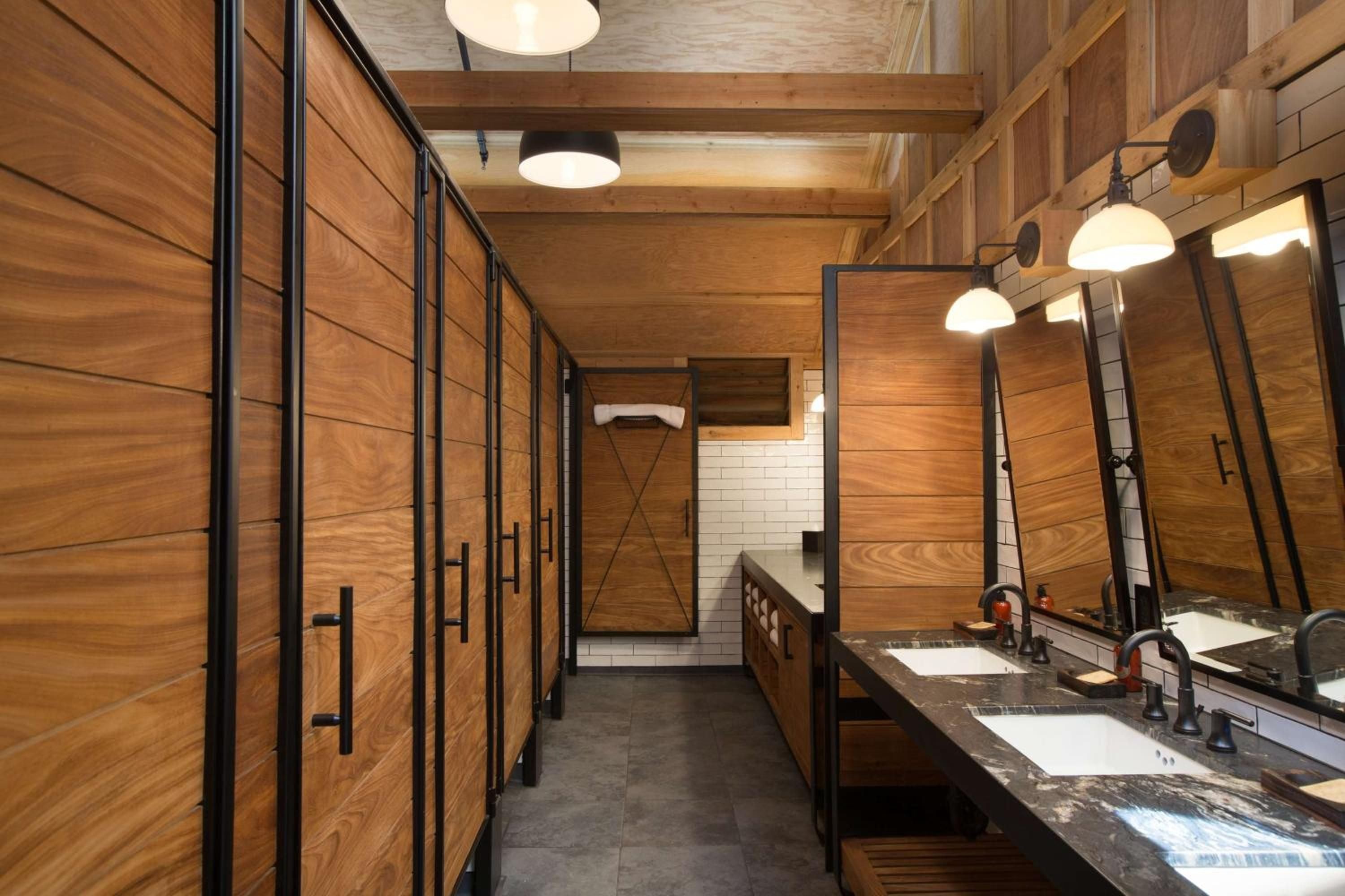 Warm cedar walls and industrial-chic black fixtures create an unexpectedly sophisticated sanctuary, where forest lodge meets modern luxury in this thoughtfully designed retreat.