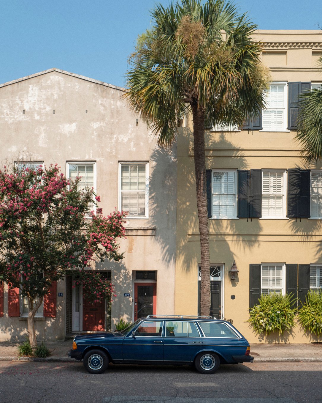 Pastel-hued Charleston row houses create a dreamy streetscape, where vintage station wagons and blooming crepe myrtles complement the city's timeless Southern charm.