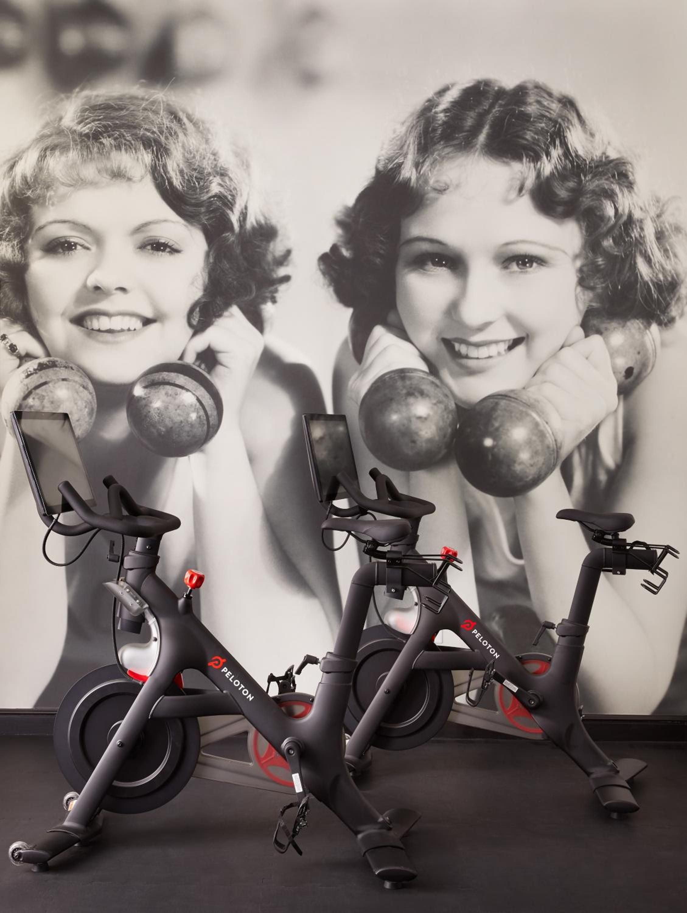 Vintage-inspired fitness equipment creates an artful contrast against classic black-and-white photography, blending nostalgic charm with modern wellness amenities in this thoughtfully designed exercise space.