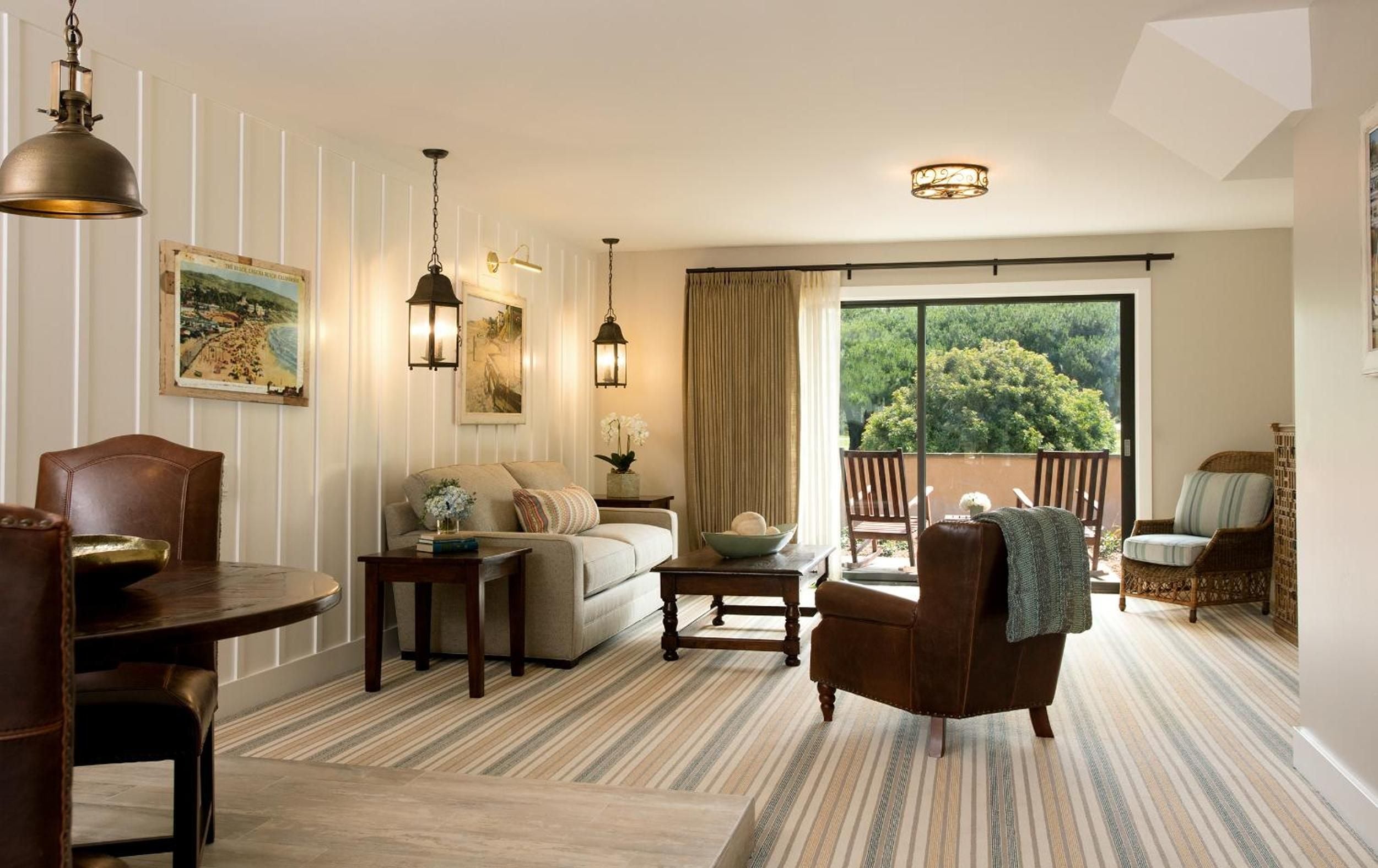 Coastal artwork and warm wood furnishings create an inviting retreat, while floor-to-ceiling windows frame verdant canyon views that epitomize Southern California's natural luxury.