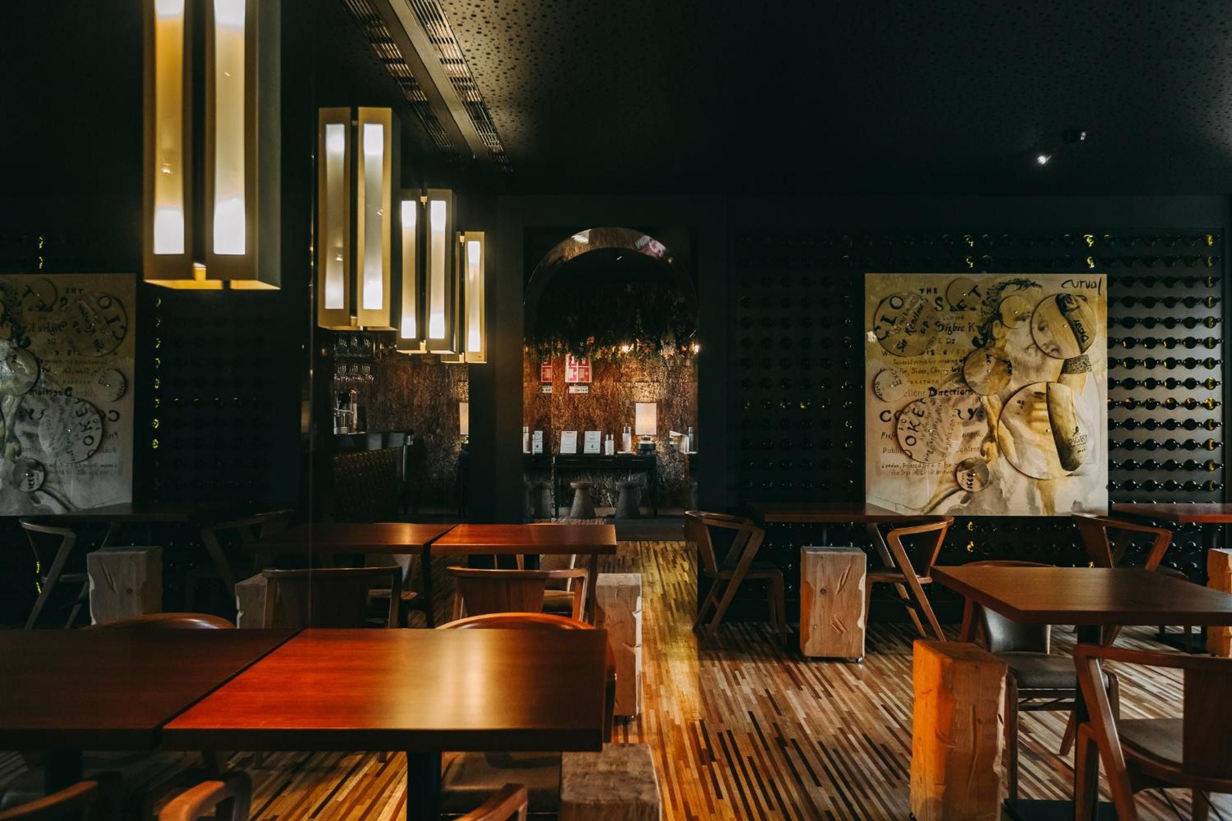 Steampunk-inspired dining room features vintage astronomical charts and copper accents, where warm pendant lights cast golden glows across polished wood tables and industrial-chic décor.