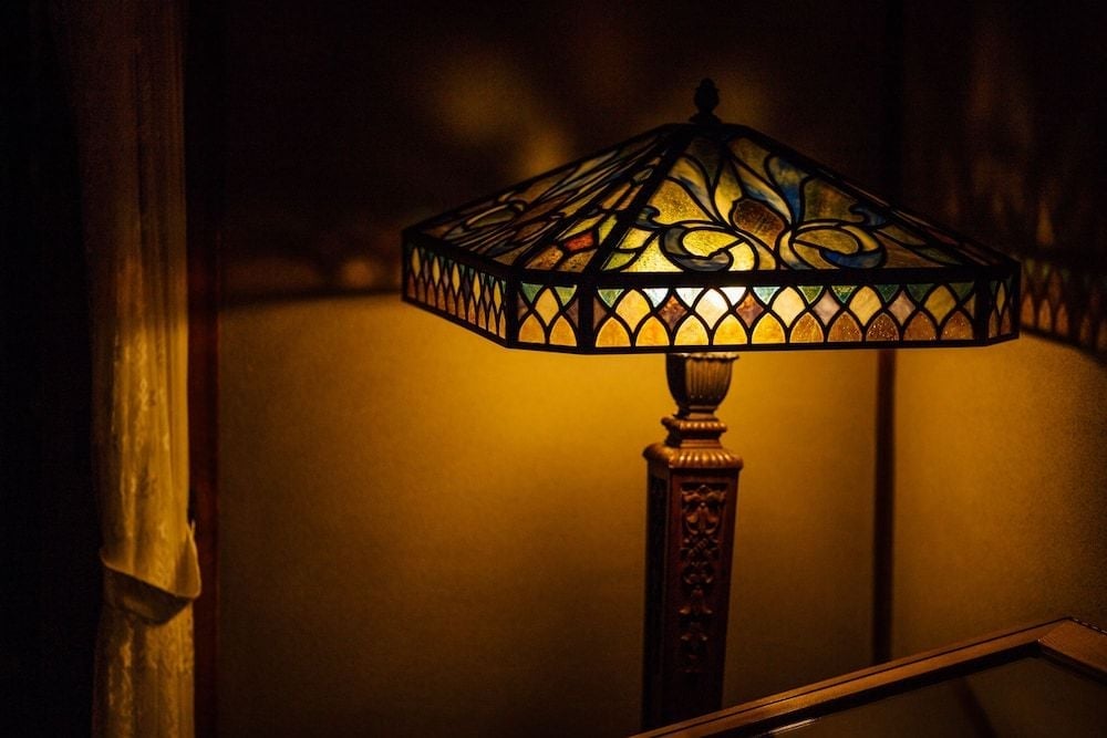 Hand-crafted Tiffany-style lampshades cast amber patterns across tatami-floored corridors, where traditional Japanese architecture meets artisanal lighting design in perfect harmony.