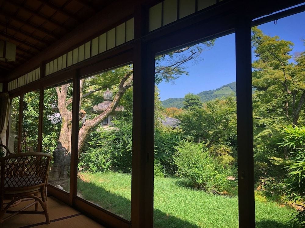 Traditional wooden frames open onto emerald gardens where ancient trees stand sentinel, creating a living artwork that changes with each season's gentle passage.