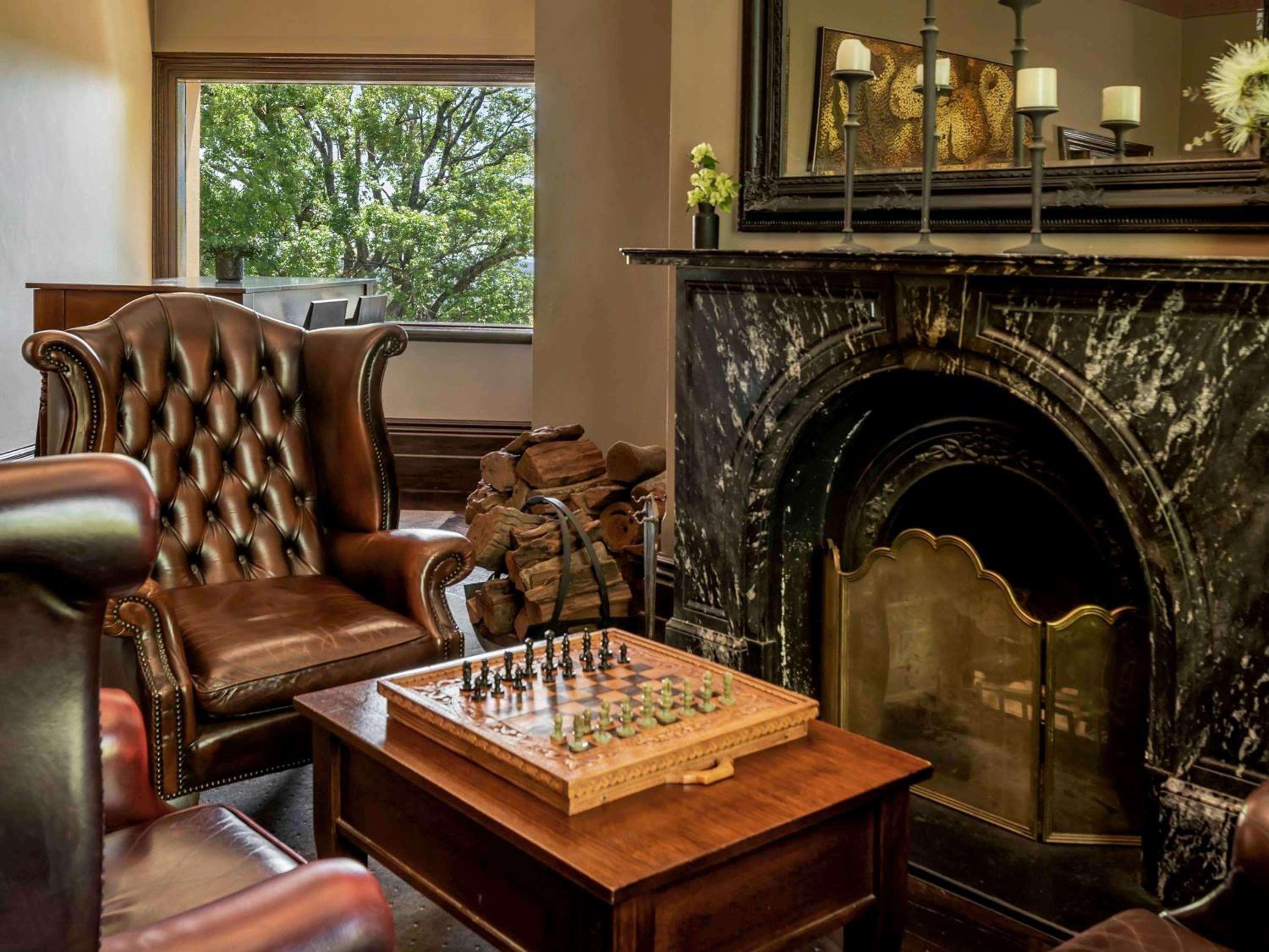Rich leather Chesterfield chairs and an ornate marble fireplace create an intimate corner where guests settle in for evening chess matches and fine whiskey.