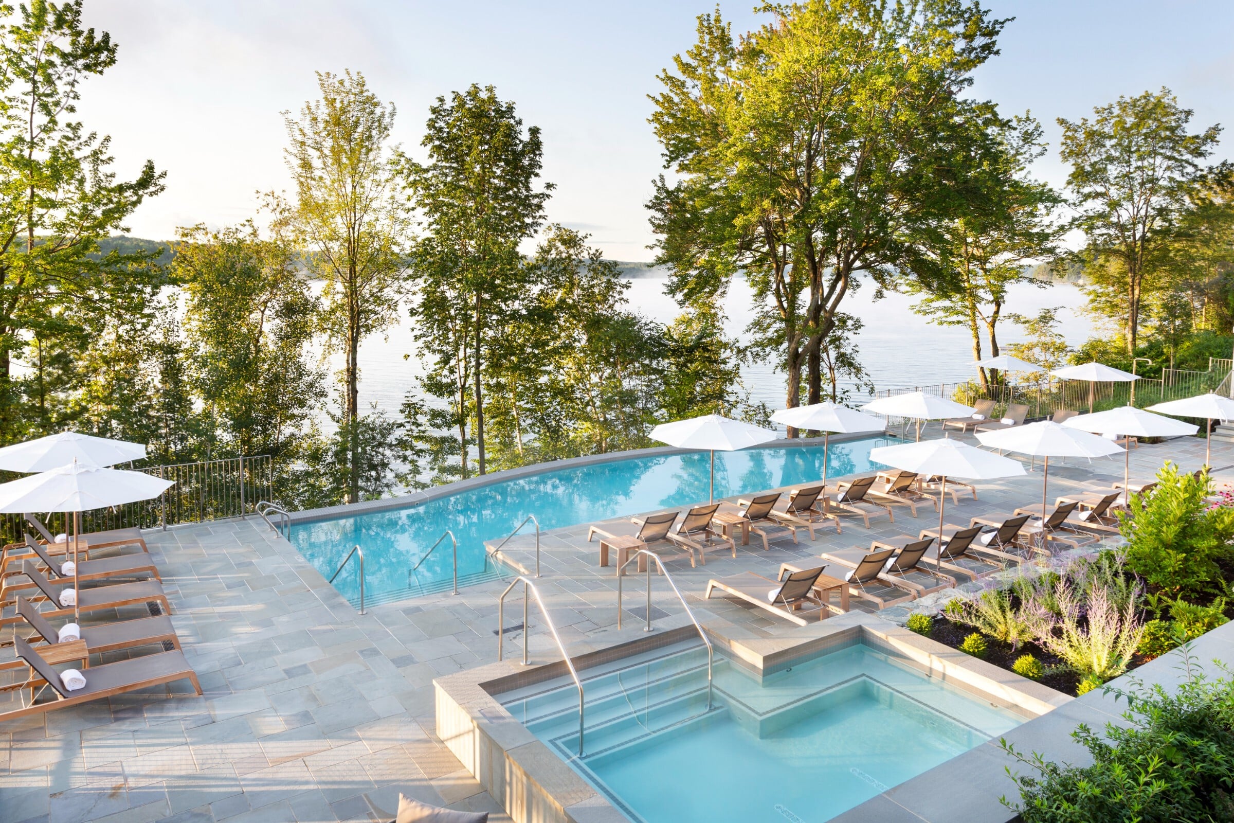 Infinity pool and spa beckon beneath towering maples, while Lake Massawippi's pristine waters shimmer through the canopy—a sublime marriage of luxury and wilderness.