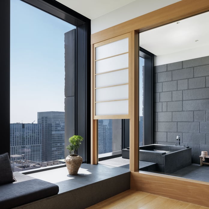 Floor-to-ceiling windows frame Tokyo's skyline from the soaking tub, while sliding shoji screens filter light through this serene urban sanctuary.