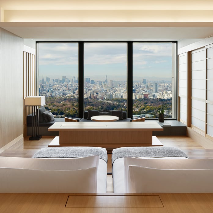 Floor-to-ceiling windows frame Tokyo's sprawling cityscape from this serene suite, where minimalist Japanese design meets urban sophistication through clean lines and warm wood accents.