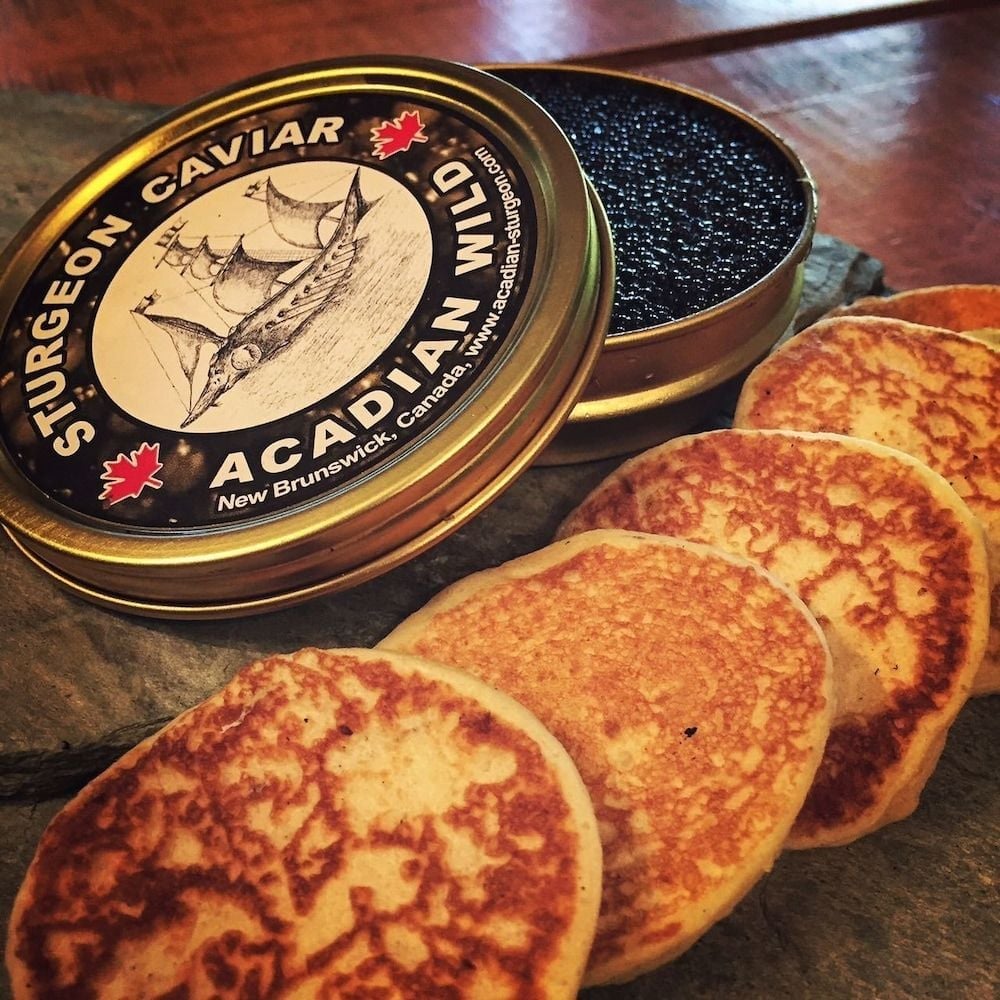 Acadian Wild sturgeon caviar from New Brunswick pairs with golden blini, showcasing the Maritime provinces' exceptional local delicacies at this wilderness retreat.