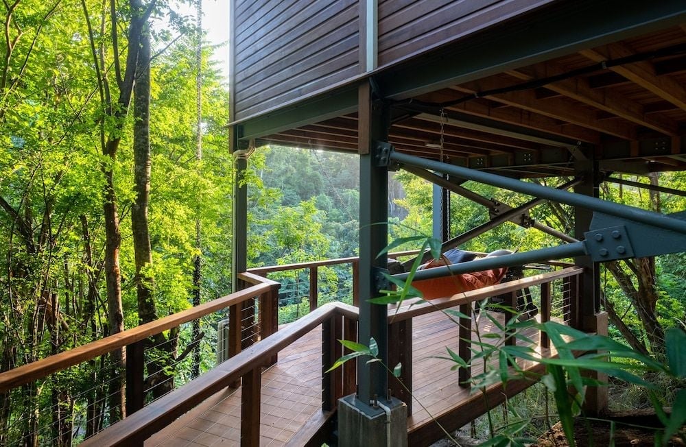 Suspended wooden decks weave through emerald canopy at Secret Bay, where steel cable railings frame jungle vistas and architectural ingenuity meets tropical wilderness.