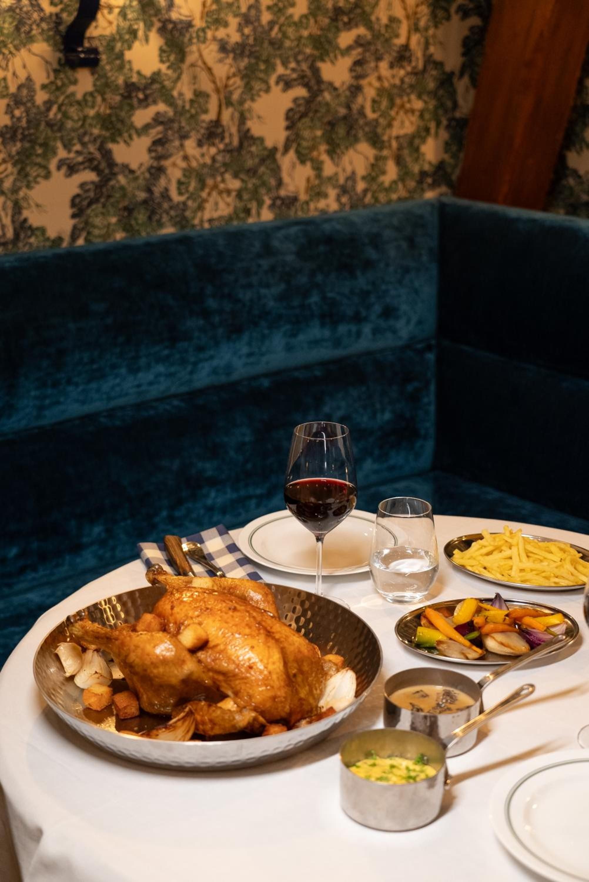 Golden-roasted chicken arrives at your candlelit table against jewel-toned velvet banquettes, where monastery-turned-hotel dining feels both intimate and grandly theatrical.