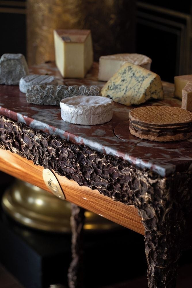 Artisanal French cheeses rest on marble surfaces, showcasing the hotel's commitment to authentic Parisian gastronomy and refined culinary craftsmanship.