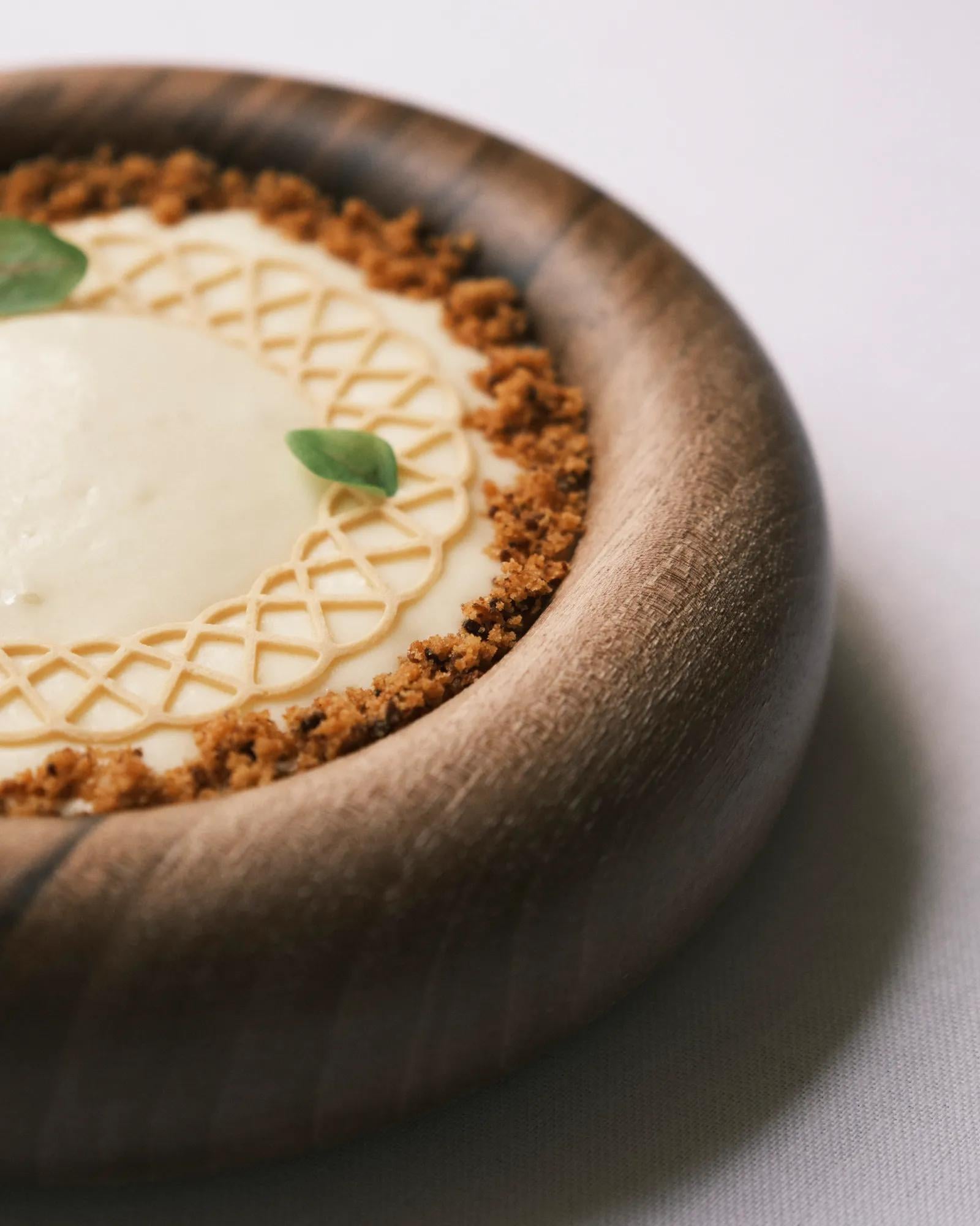 Artfully plated dessert showcases the abbey's culinary finesse, where pastry cream meets crumbled earth tones in a rustic ceramic bowl that whispers of monastery traditions.