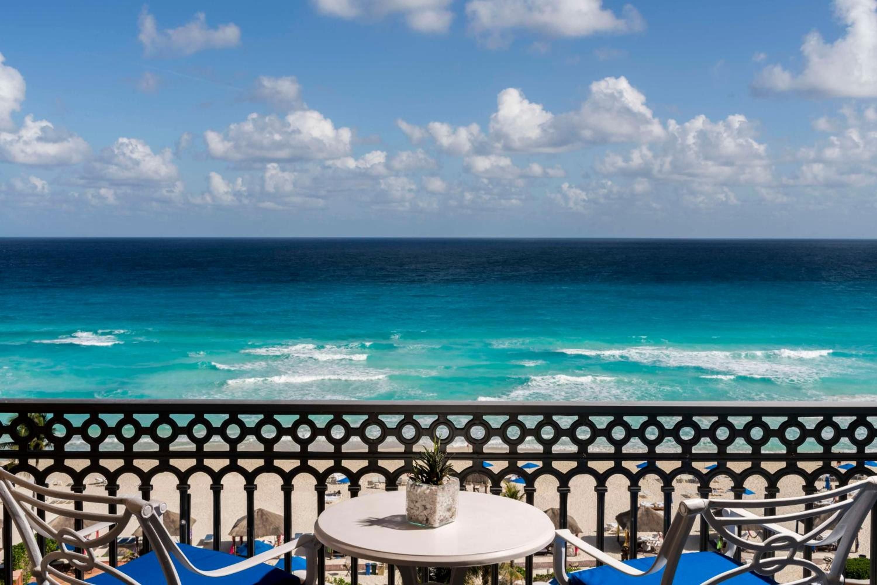 Turquoise waves crash endlessly below your private balcony, where ornate ironwork frames the Caribbean's infinite blues and afternoon breezes carry salt-kissed whispers.