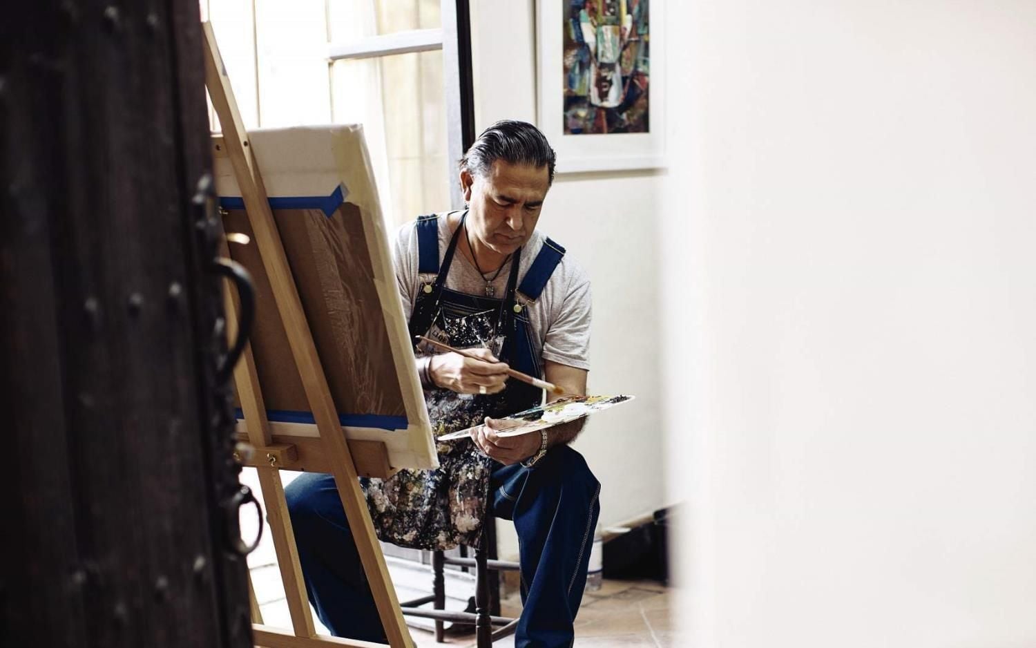 Natural light streams across an artist's workspace where paintbrush meets palette, capturing the creative spirit that flows through San Miguel's cobblestone streets into every corner.