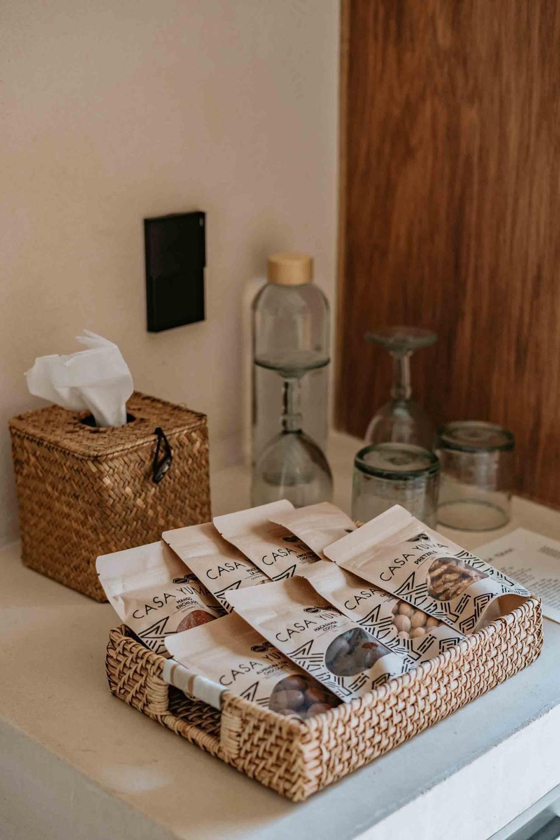 Woven baskets cradle artisanal chocolates and local treats, while glass vessels catch afternoon light filtering through warm wood panels in this thoughtfully curated space.