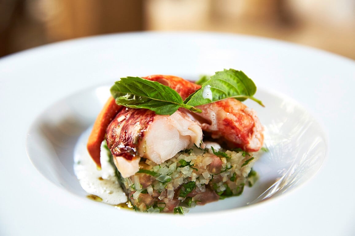 Artfully plated seafood glistens atop herbed grains, finished with fresh basil and vibrant sauces that showcase the palace's refined Moroccan-Mediterranean culinary artistry.