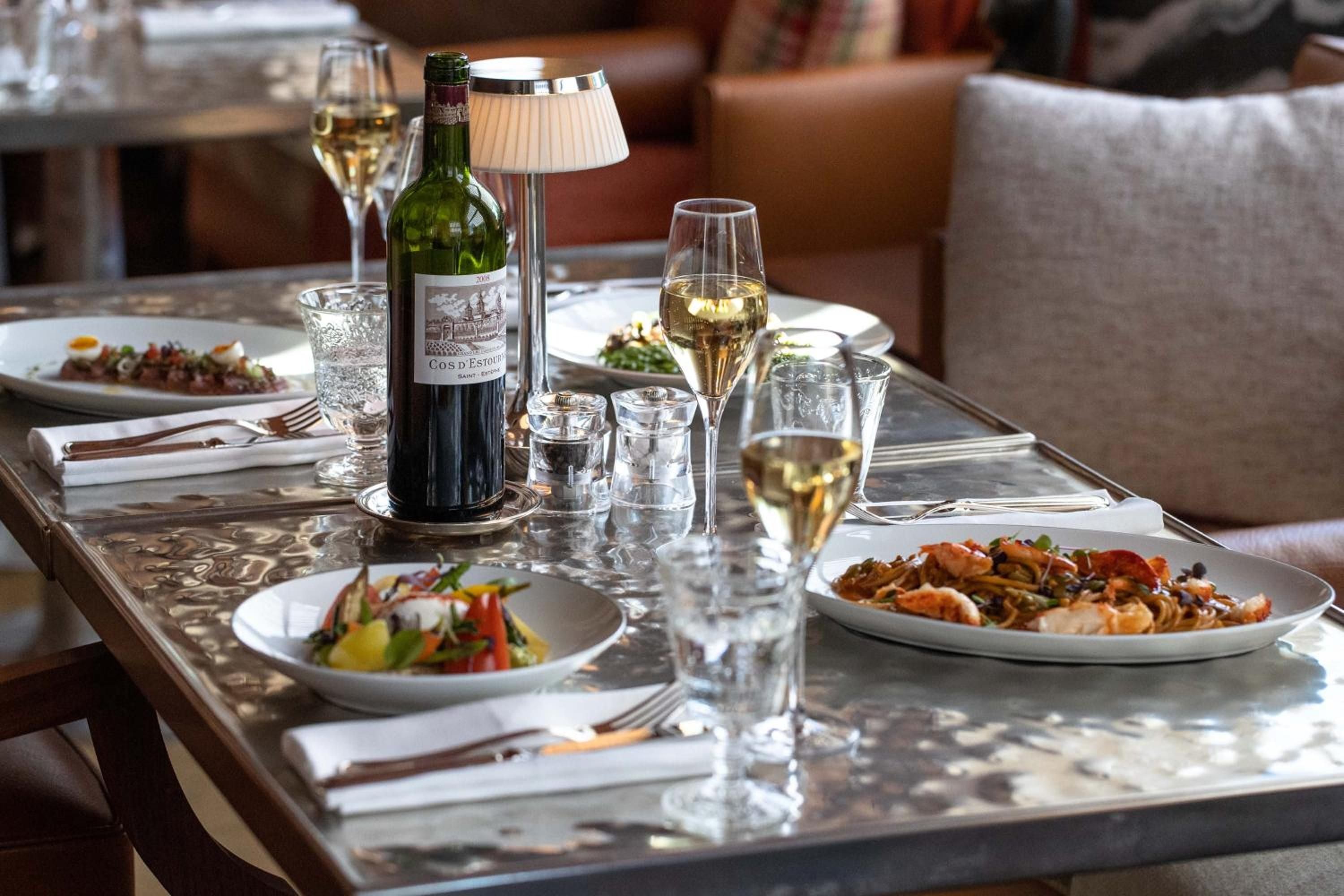 Crystal flutes catch afternoon light as Cos d'Estournel flows beside artfully plated dishes, transforming lunch into an intimate celebration of Swiss hospitality.