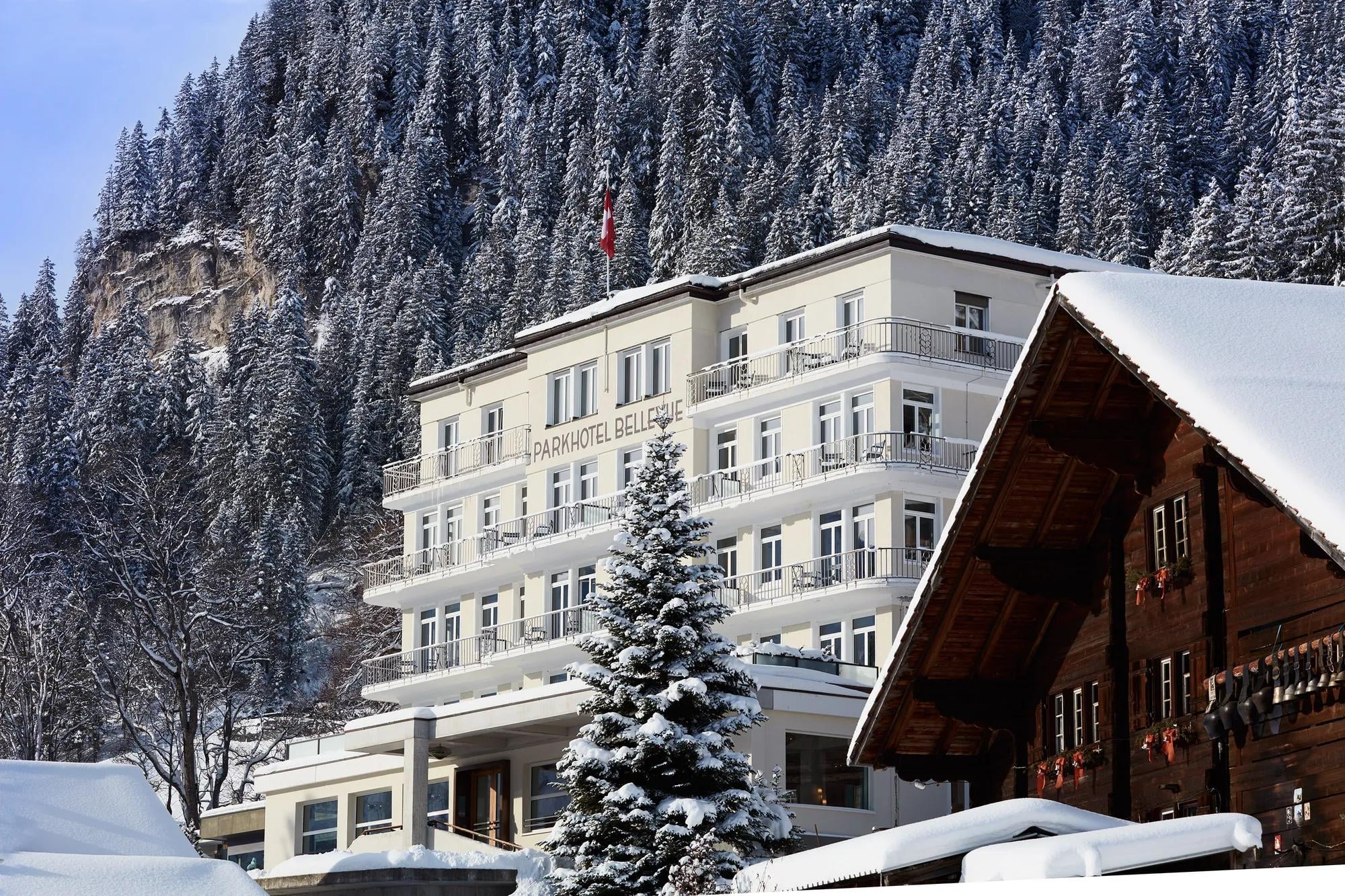 Snow-dusted balconies frame mountain vistas while traditional alpine chalets nestle beside modern elegance, creating an enchanting winter tableau in the Swiss countryside.