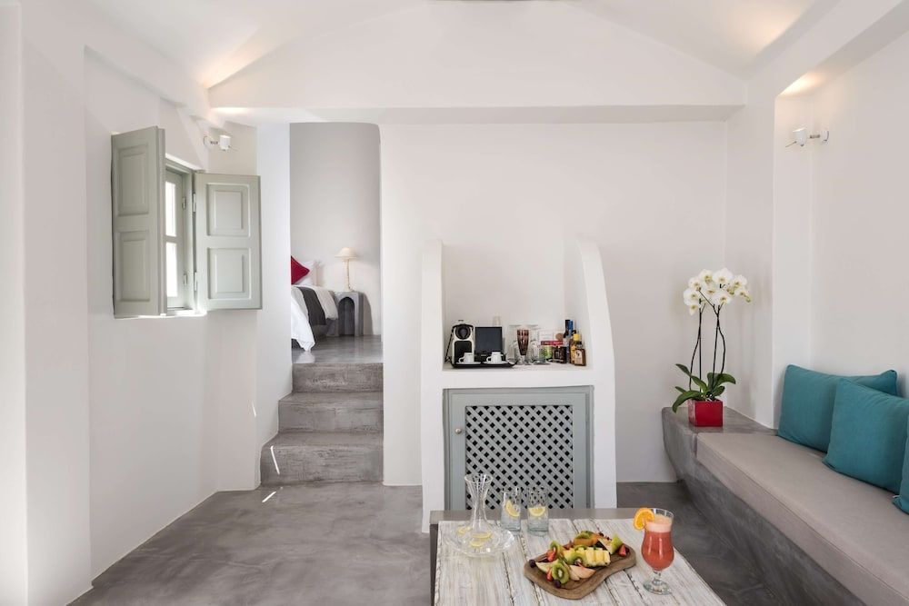 Whitewashed walls and polished concrete floors create serene minimalism, while turquoise cushions and fresh orchids add Mediterranean warmth to this split-level sanctuary.