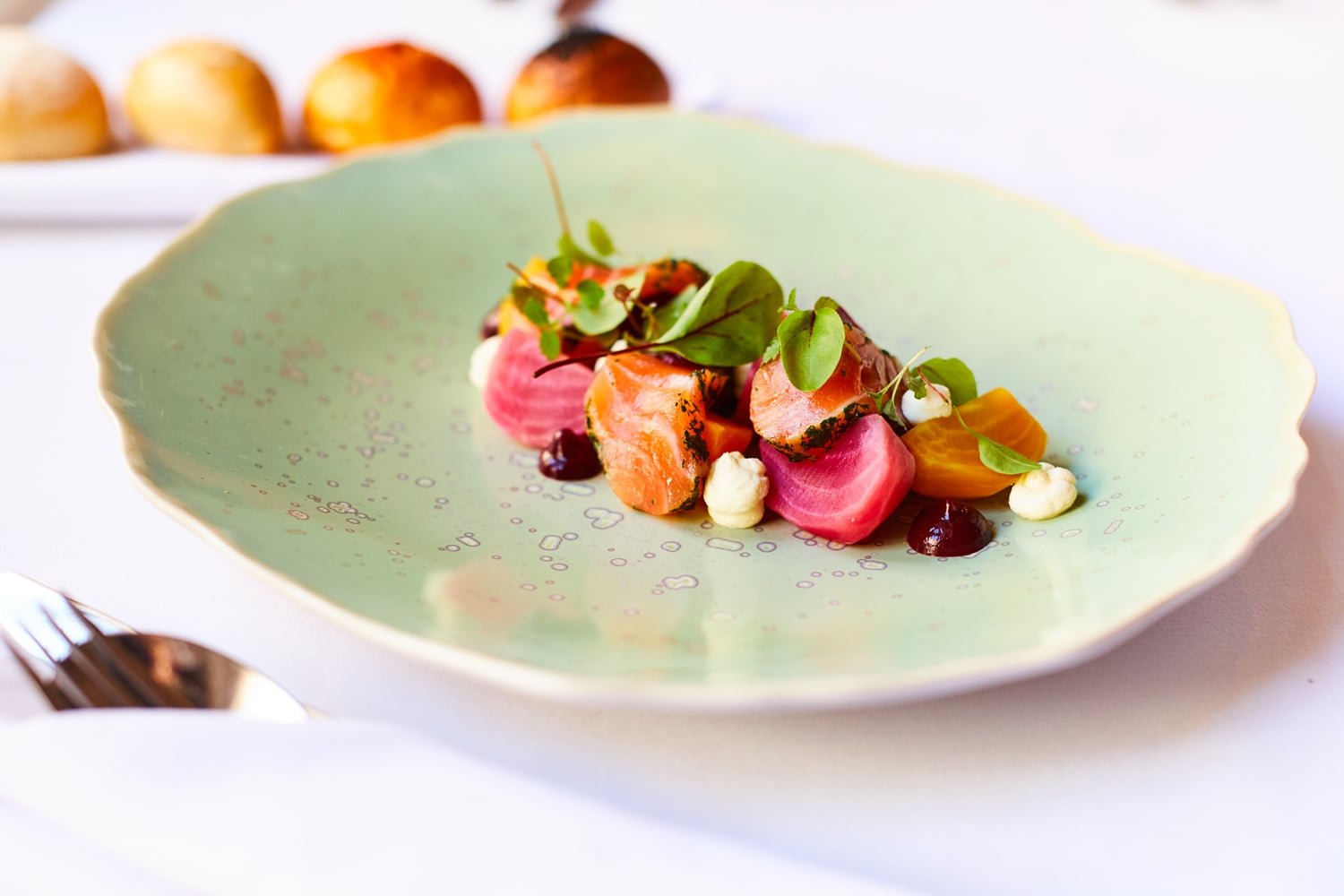 Artfully plated beetroot and salmon create a vibrant composition on sage-green porcelain, showcasing the castle's commitment to elegant, locally-inspired fine dining.