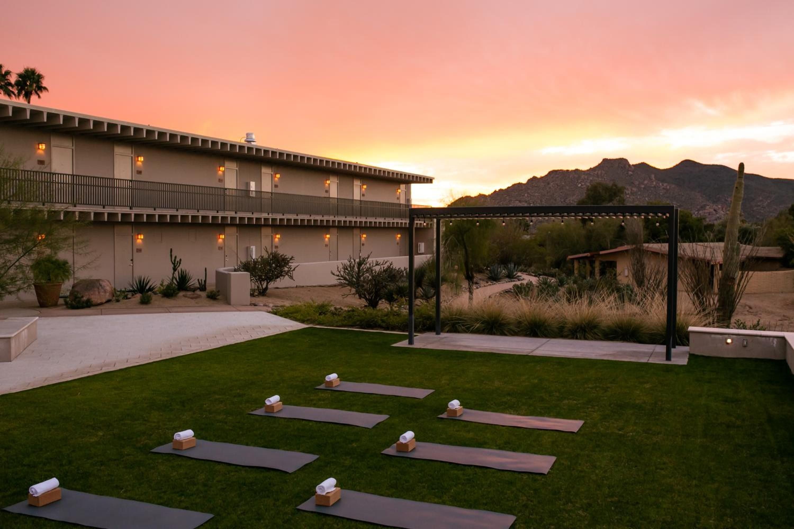 Desert sunset bathes outdoor yoga mats in golden light as mountains frame CIVANA's serene wellness sanctuary, where mindfulness meets Arizona's raw beauty.