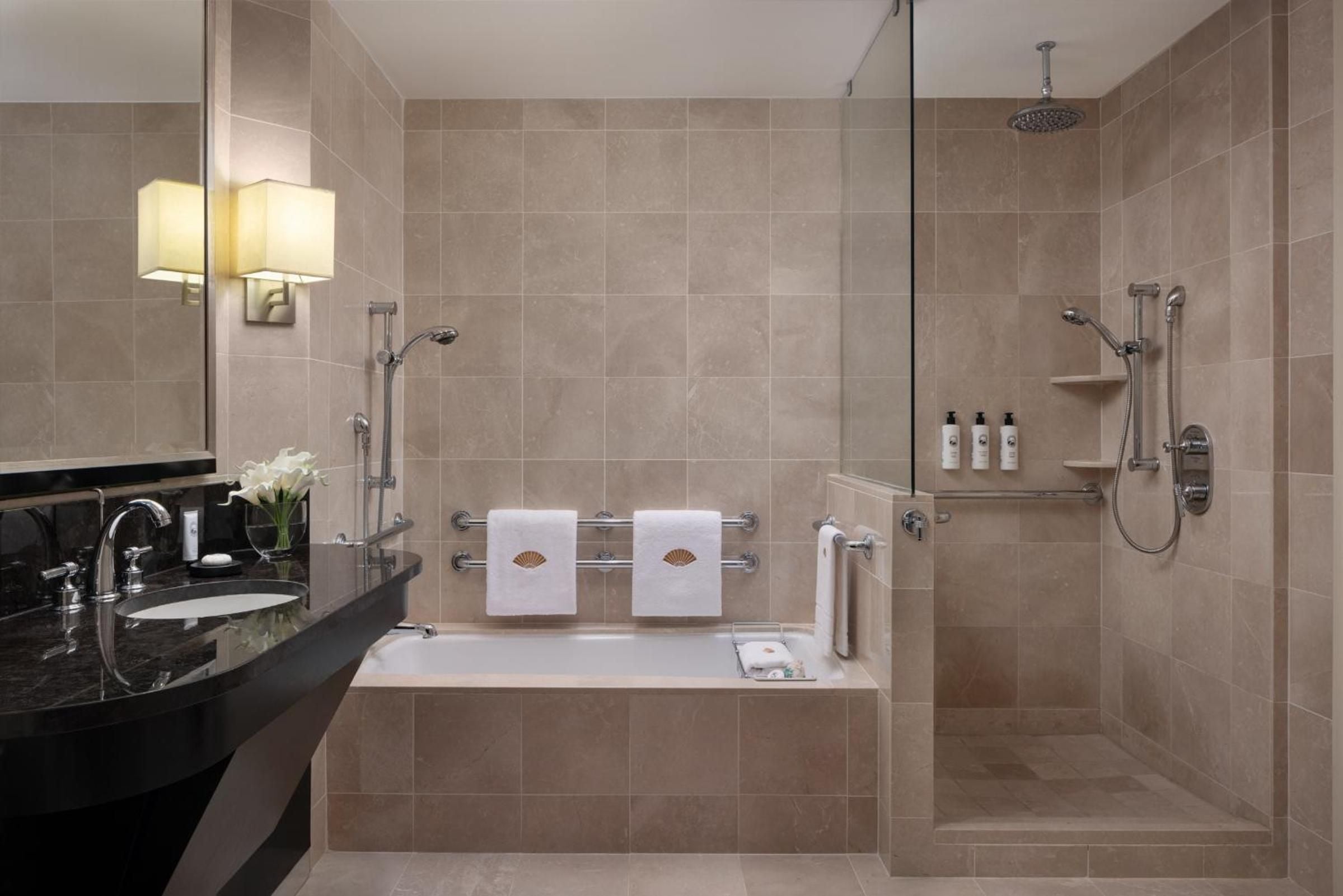 Marble and limestone create a spa-like sanctuary where rainfall showers and deep soaking tubs invite long, luxurious rituals above the Manhattan bustle.