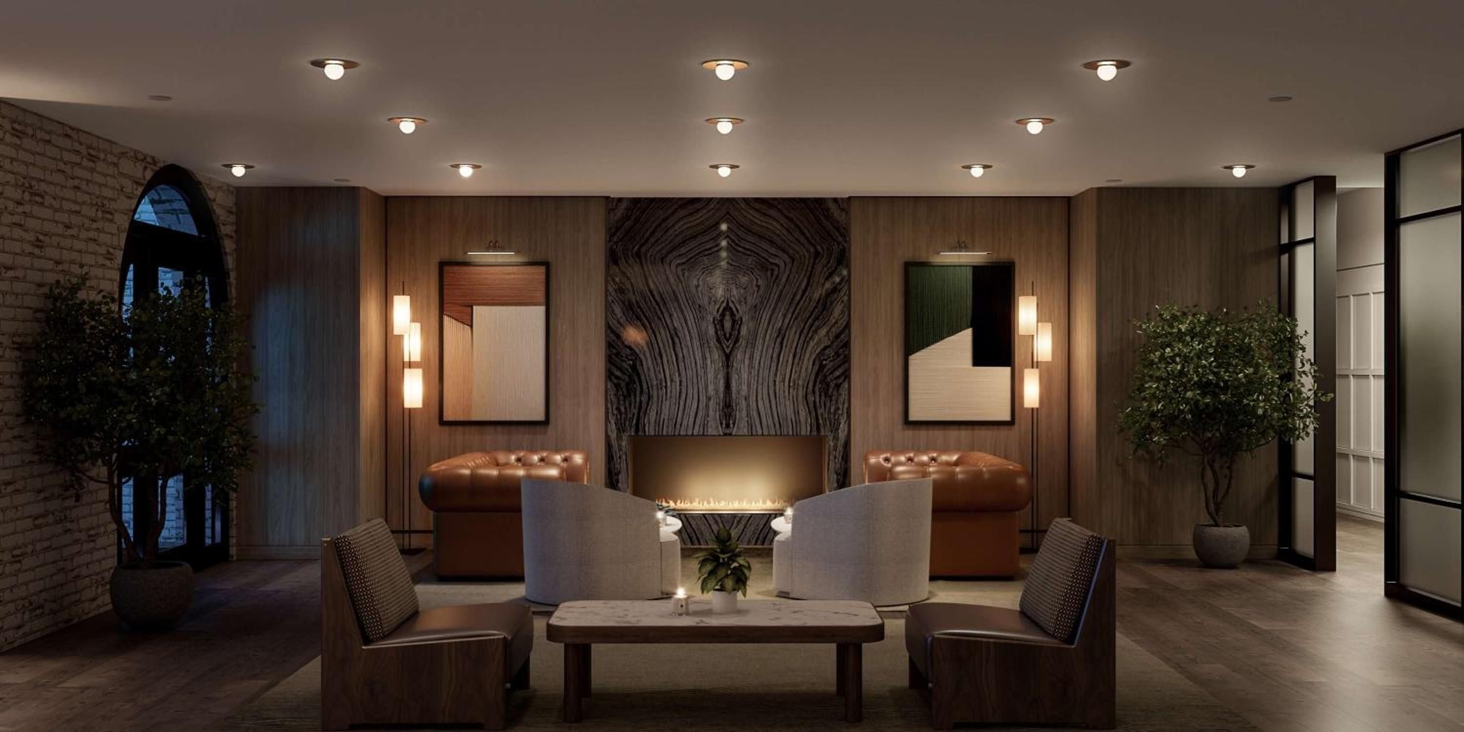 Warm recessed lighting illuminates the sophisticated lobby lounge, where leather Chesterfield chairs and dramatic wood grain wallpaper create an inviting urban retreat.