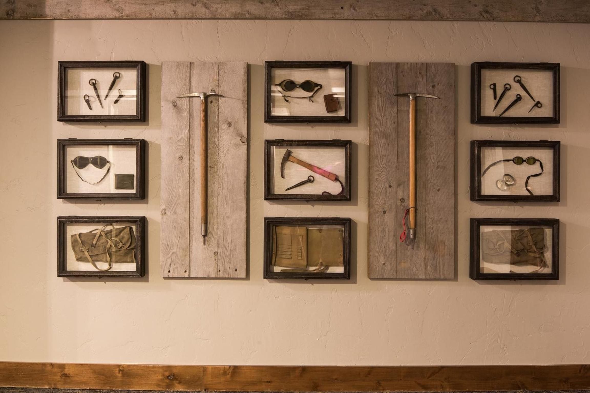 Rustic shadow boxes showcase vintage mountain tools and memorabilia, creating an intimate museum of frontier life within the lodge's thoughtfully curated common spaces.
