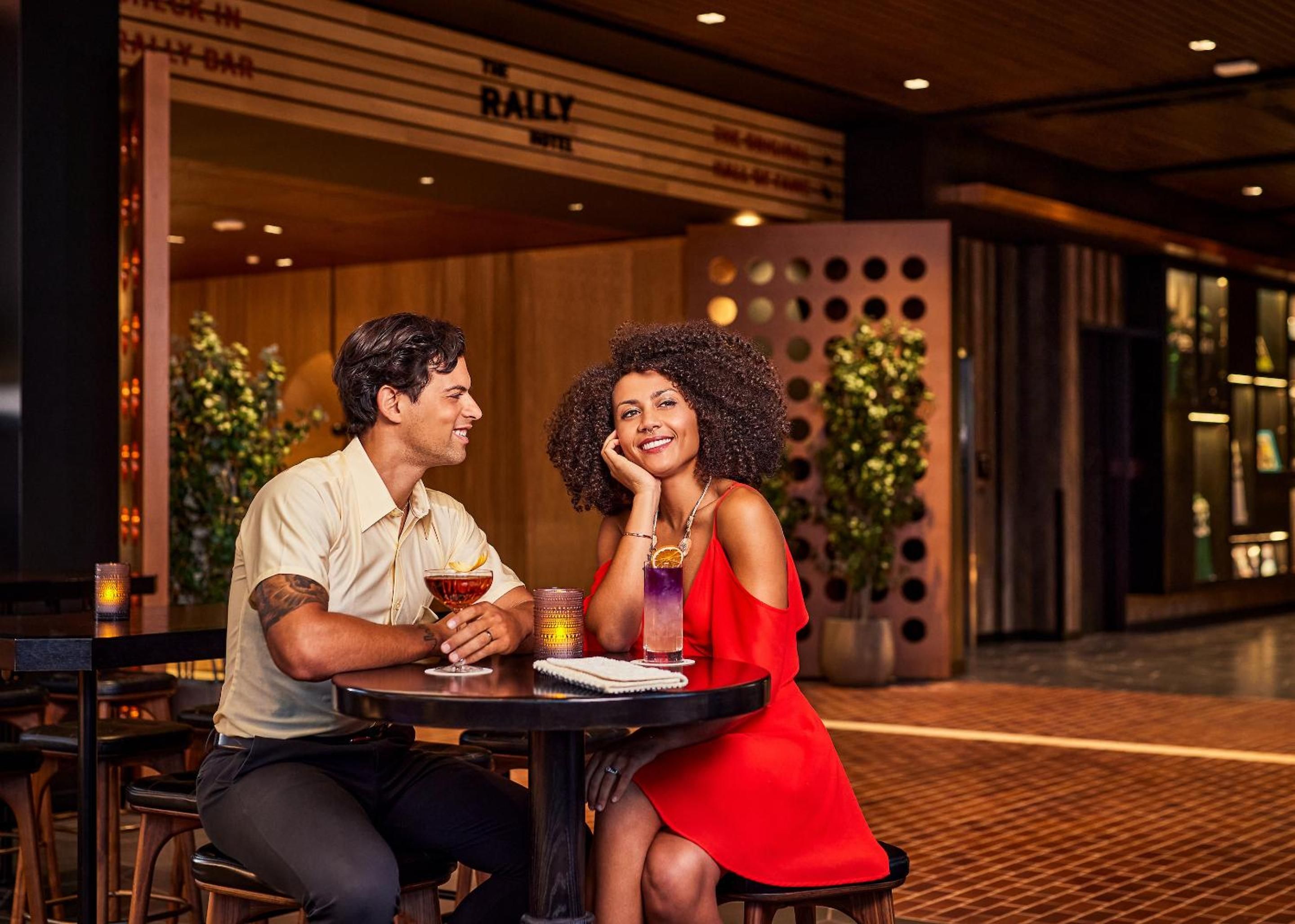 Guests savor craft cocktails at the hotel's stylish bar, where warm wood tones and modern design create an inviting atmosphere for evening conversations.