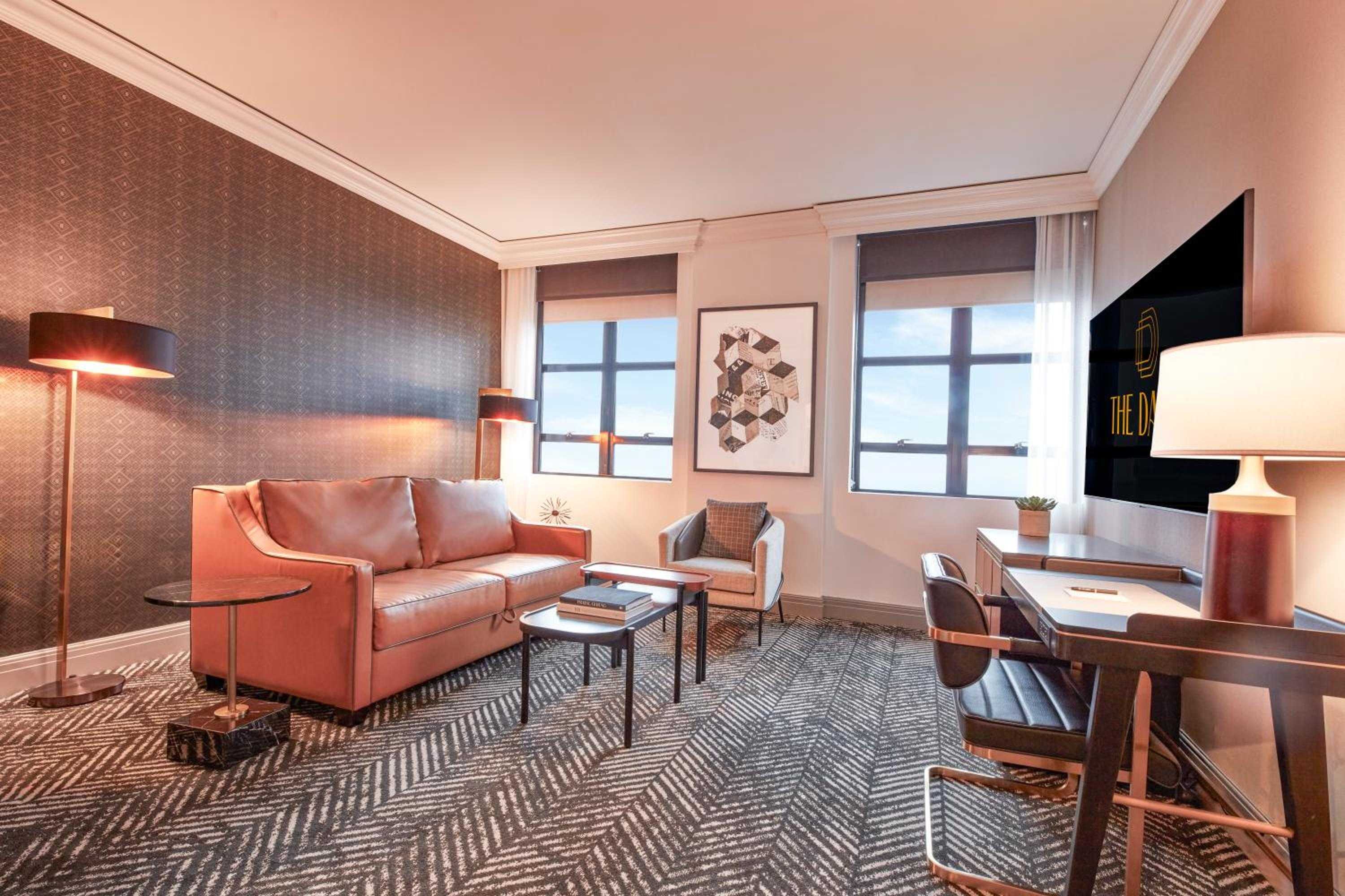 Warm copper accents and rich textiles create an inviting retreat, where geometric patterns and amber lighting transform a corner suite into sophisticated urban sanctuary.