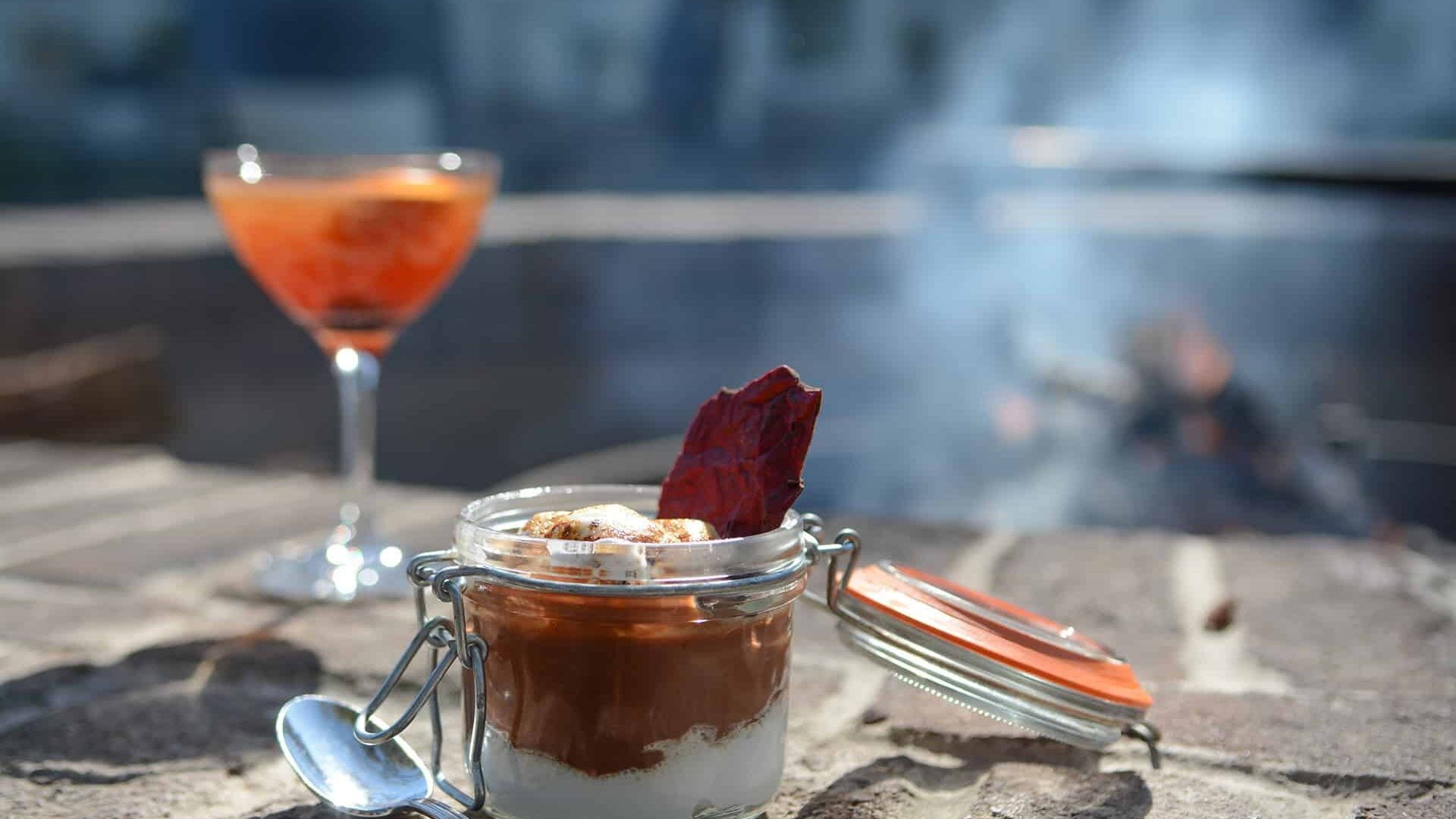 Layered dessert in a mason jar and craft cocktail catch golden hour light on weathered wood, where Low Country charm meets refined dining.