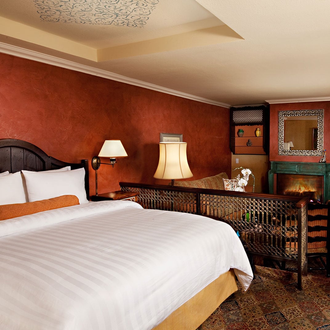 Moroccan-inspired textures warm this intimate suite, where intricate metalwork, terra cotta walls, and flickering firelight create an exotic urban sanctuary above West Hollywood.